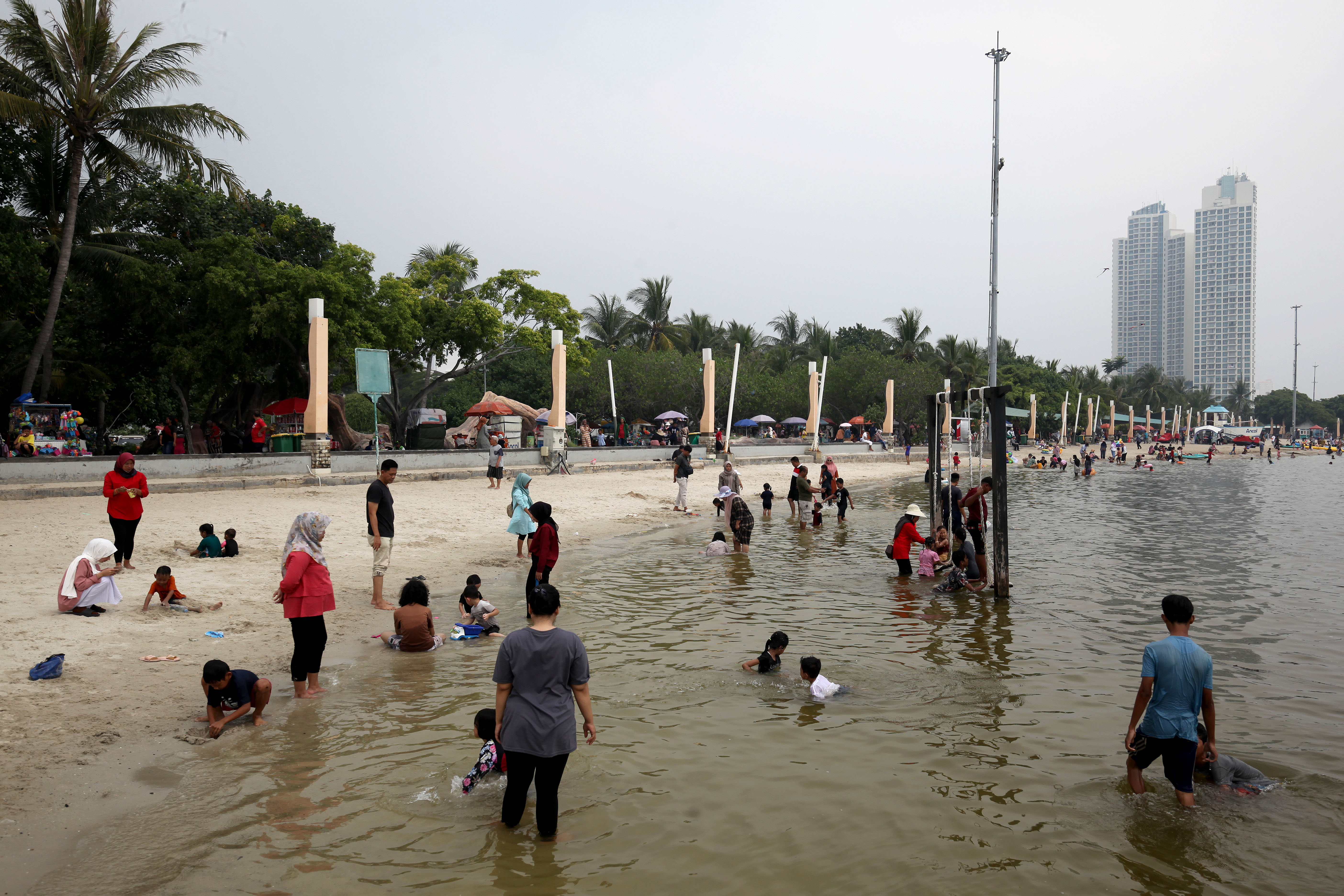 Wisatawan memadati lokasi wisata Pantai Ancol di Jakarta, Selasa (18/6/2024).