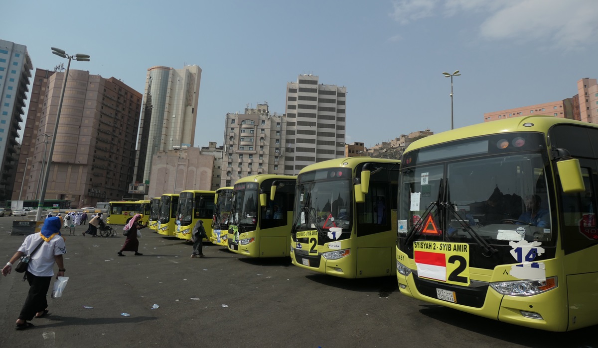 Jamaah haji Indonesia melintas di depan bus Shalawat di Terminal Syib Amir, Makkah, Arab Saudi, Kamis (20/6/2024). 