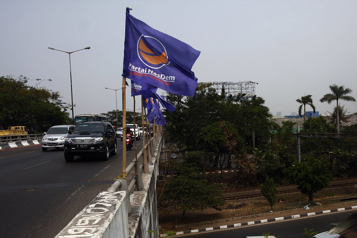Bendera Partai NasDem terpasang di pinggir jalan layang Permata Hijau, Jakarta, Senin (21/9/2015).