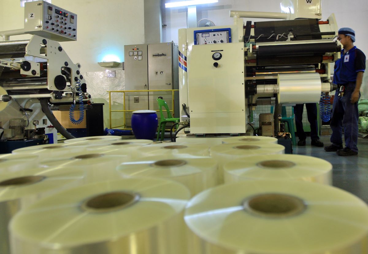 karyawan tengah mengoperasikan mesin penggulung plastik milik PT Indopoly Swakarsa Industry di Purwakarta, Jawa Barat.