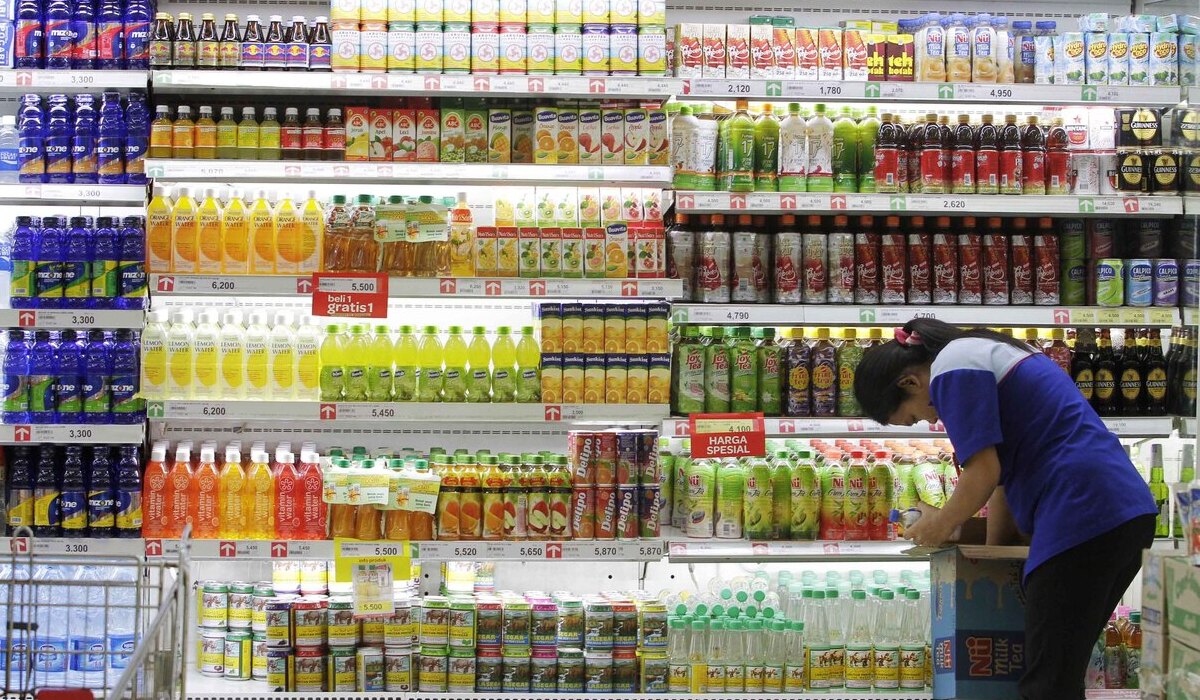 Petugas menyusun jajaran botol minuman berpemanis dalam kemasan (MBDK).