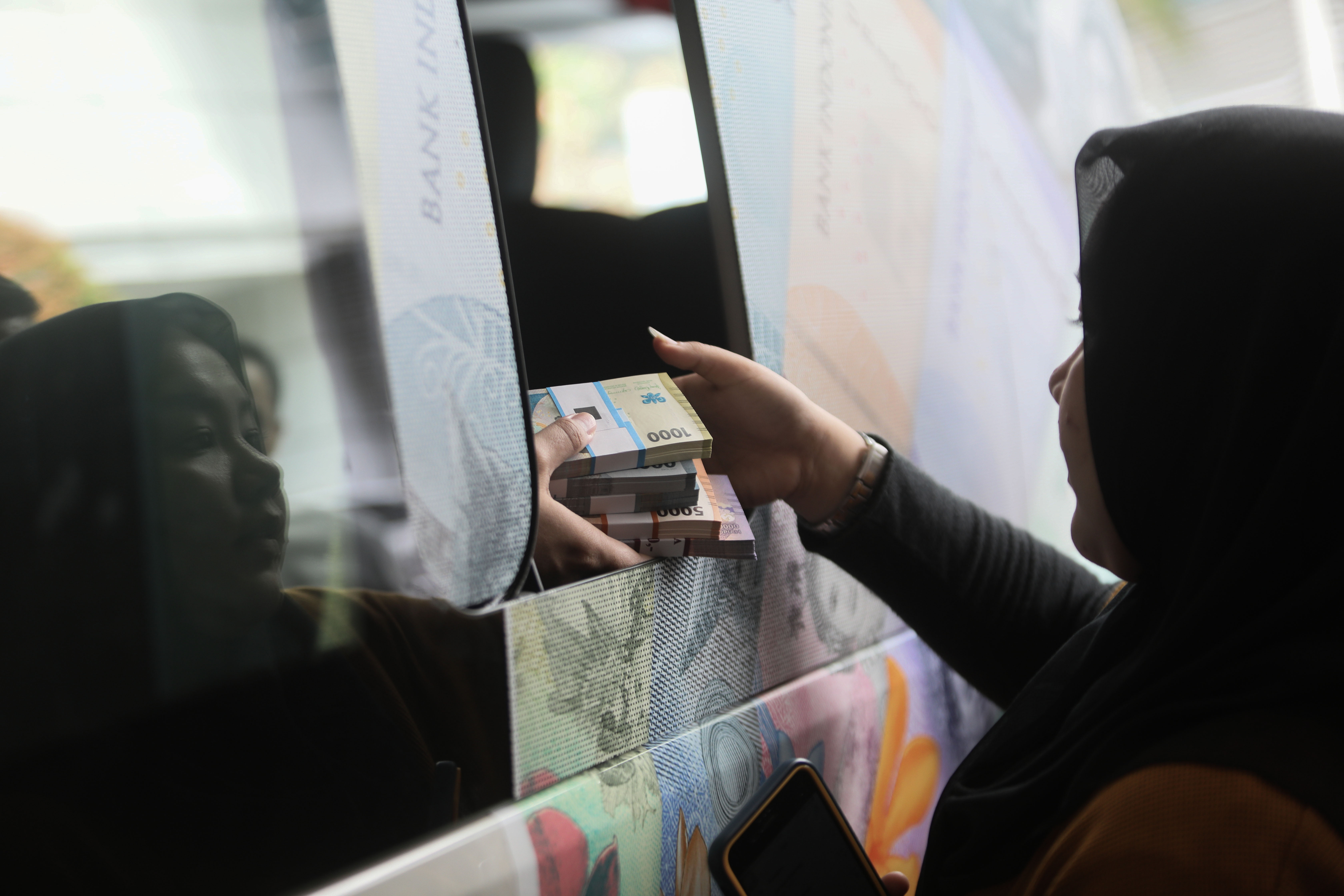 Karyawan Media Group melakukan penukaran uang pecahan rupiah baru di Kompleks Media Group (3/4/2024).