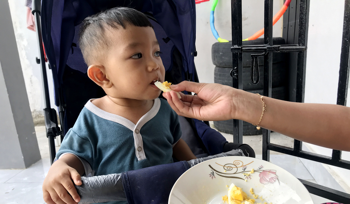 Ilustrasi: sorang balita mengkonsumsi telur ayam yang disuap oleh ibunya 