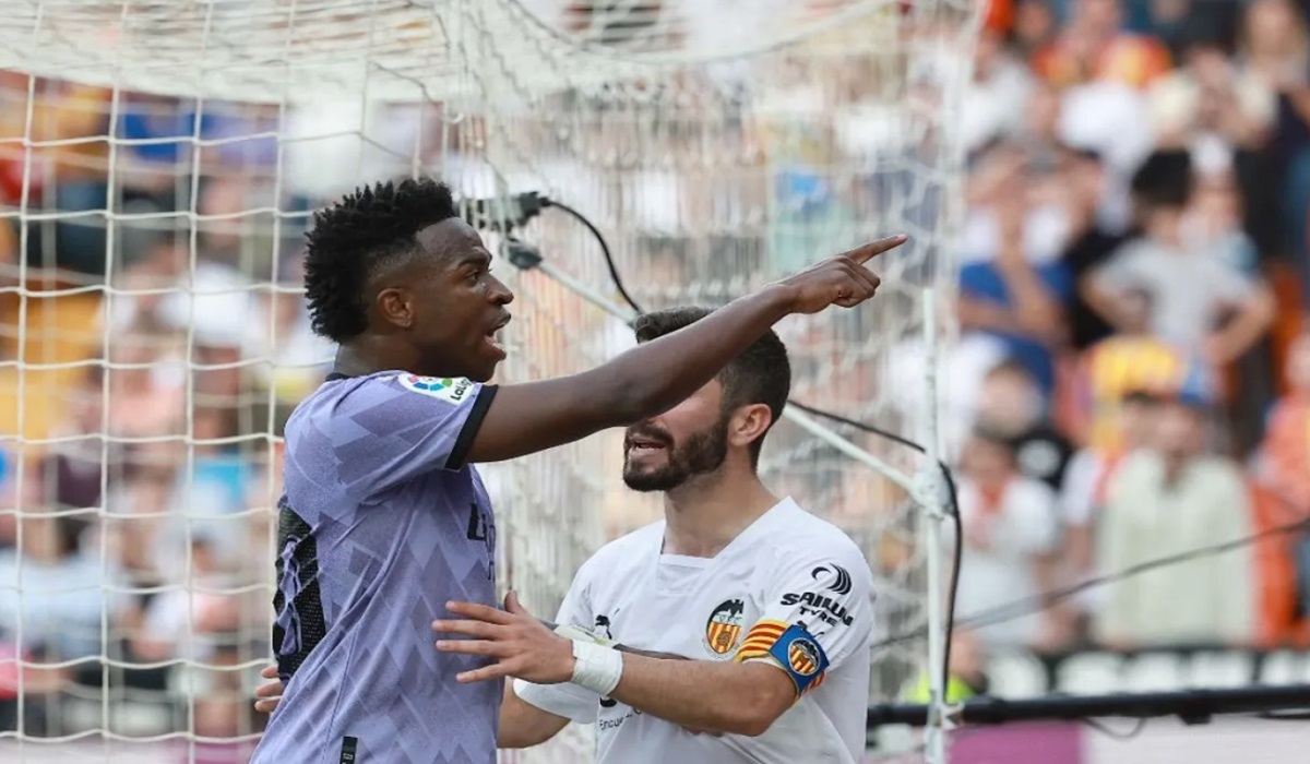 Penyerang Real Madrid Vinicius Junior bereaksi usai menjadi sasaran aksi rasisme dari pendukung Valencia, Minggu (21/5/2023).