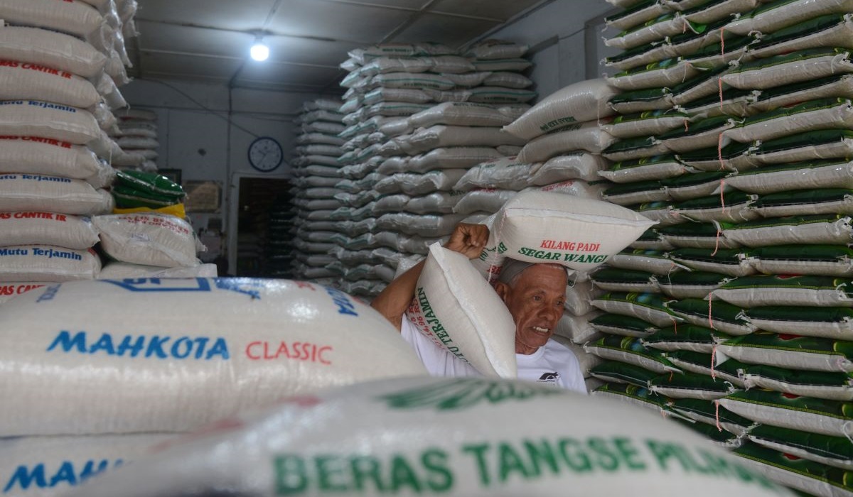 Pekerja mengangkut beras kualitas premium di toko grosir pasar tradisional Kampung Baru, Banda Aceh, Aceh, Kamis (25/4/2024).