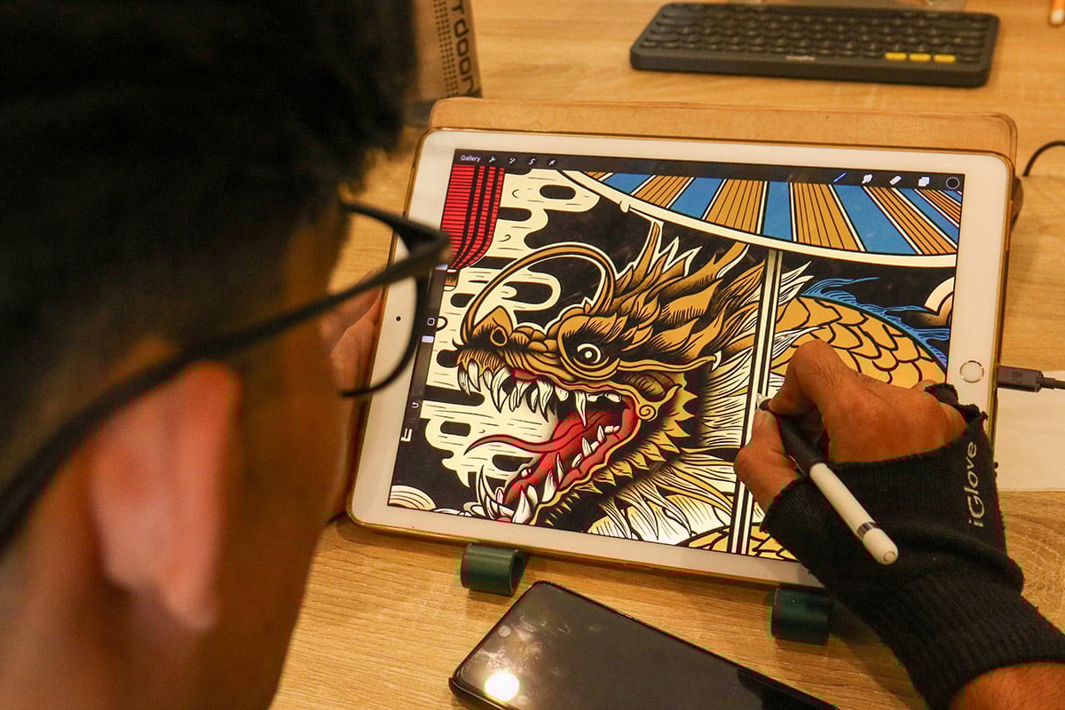 Pelaku seni desain grafis mendesain di rumah produksi nya di Banyuwangi, Jawa Timur, Senin (29/1)