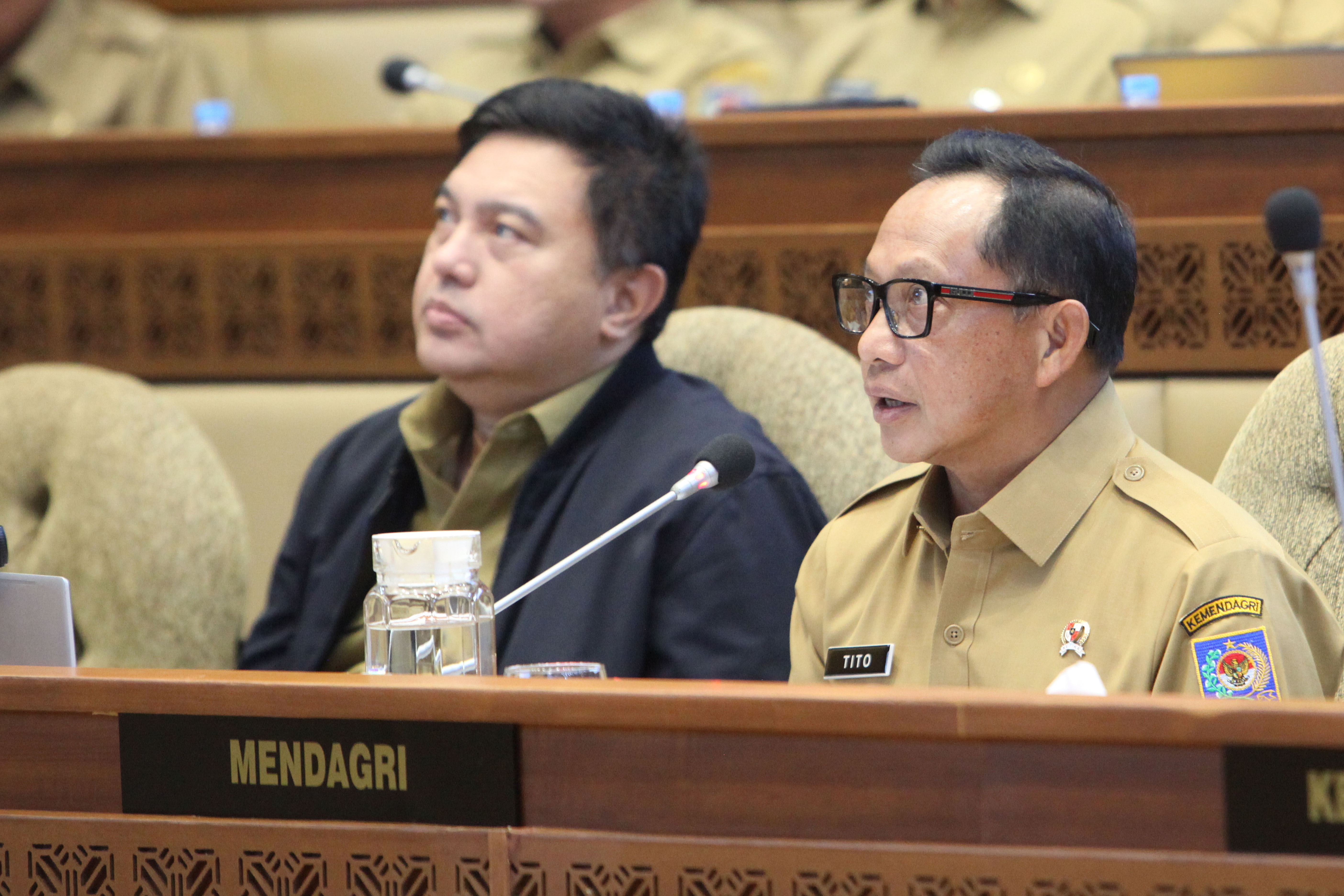 Menteri Dalam Negri Tito Karnavian (kanan) memberikan penjelasan saat mengikuti rapat kerja dengan Komisi II 