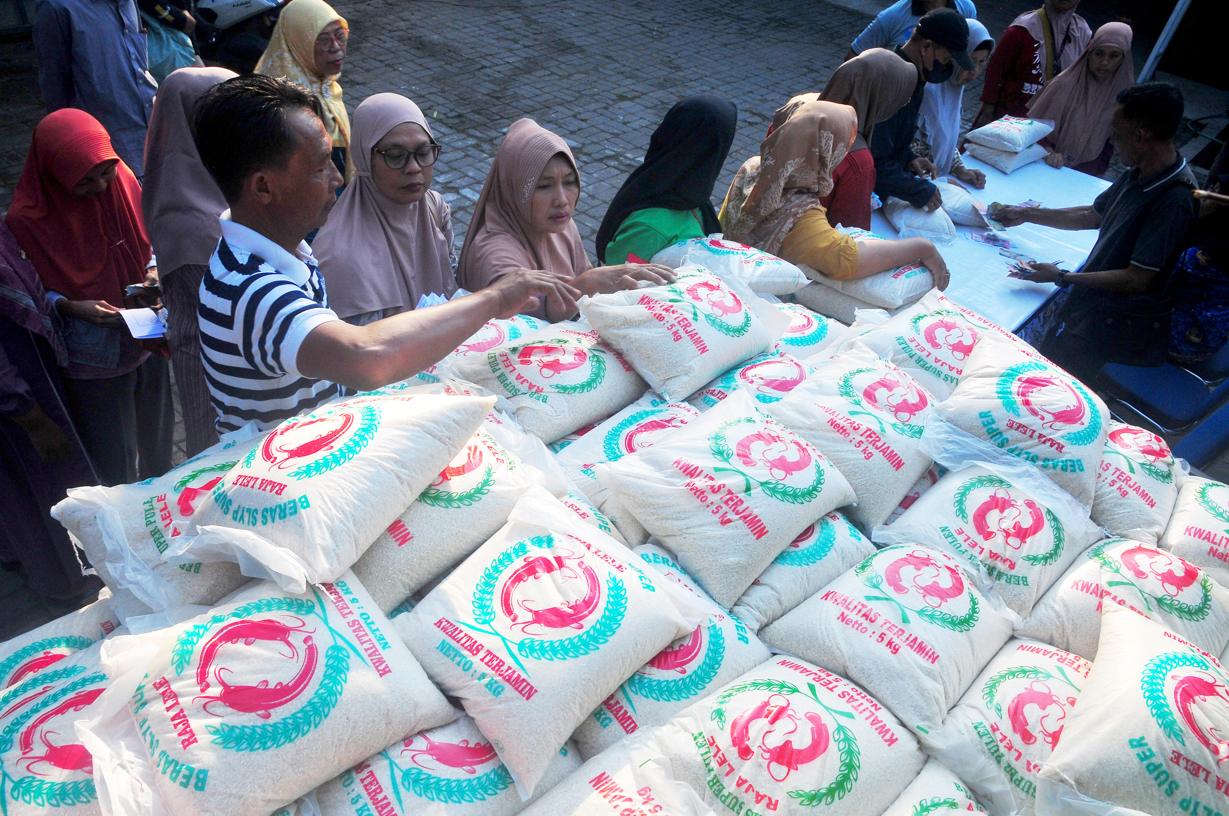 Warga antre membeli beras saat kegiatan pasar murah