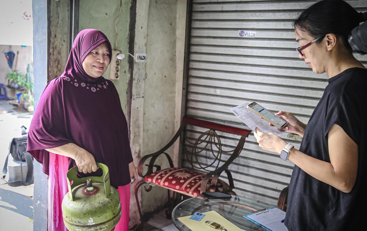 Pemilik pangkalan elpiji 3 kg (kanan) mencatat NIK KTP warga pembeli tabung gas subsidi