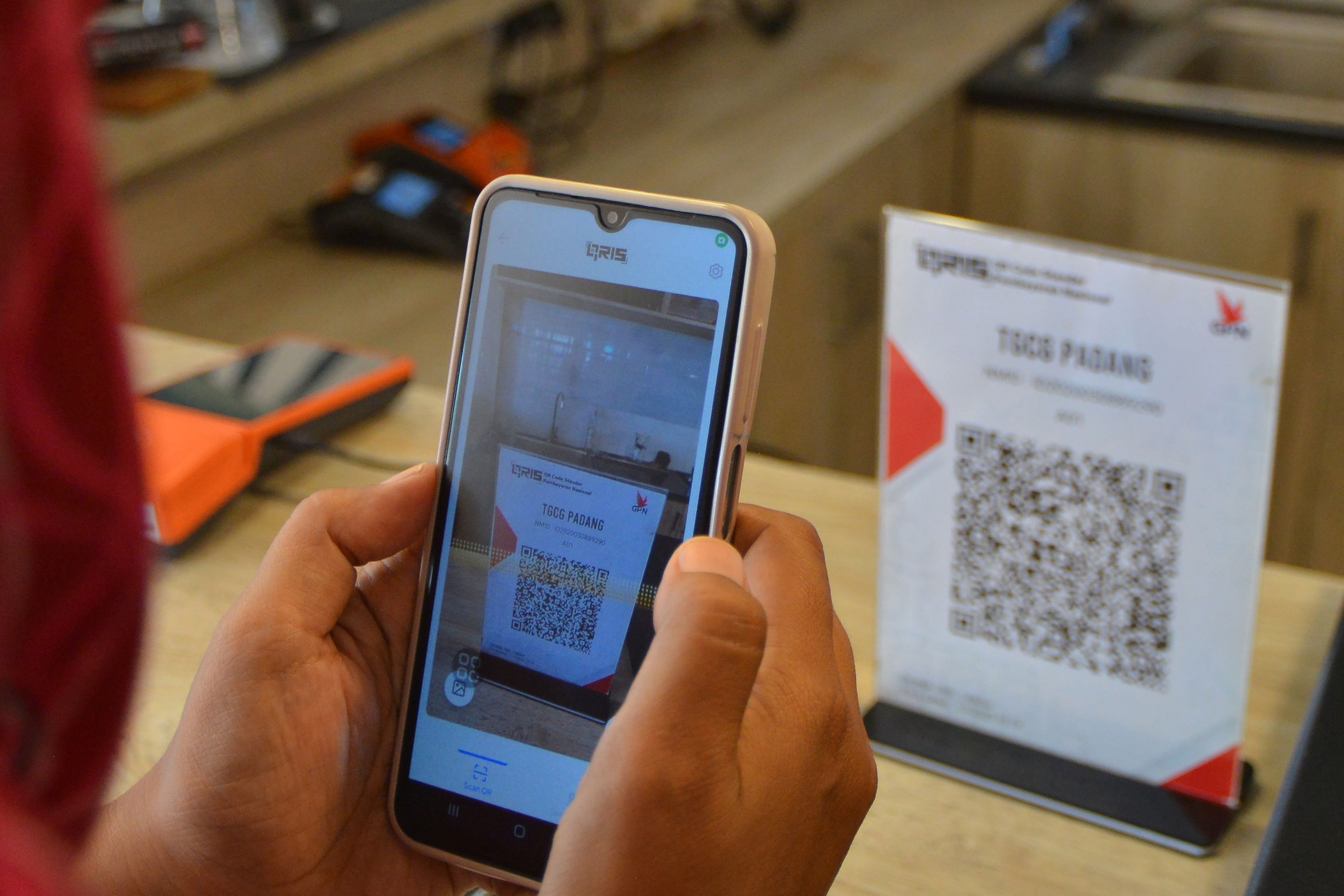 Konsumen melakukan pembayaran non tunai menggunakan QRIS di Gade Coffe Padang, Sumatra Barat, Senin (26/2/2024)