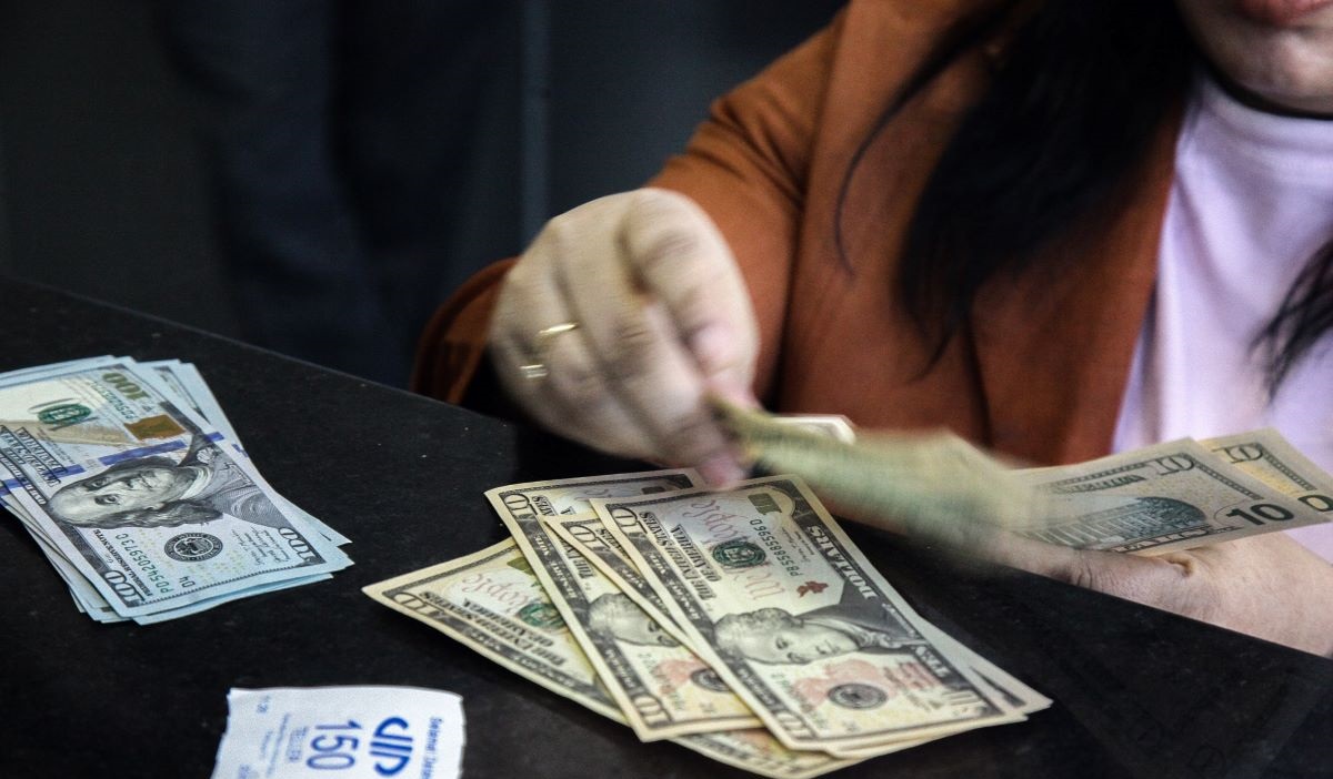 Petugas menghitung uang pecahan dolar AS dan rupiah di gerai jasa penukaran mata uang asing, ,Menteng, Jakarta Pusat, Kamis (20/6/2024).