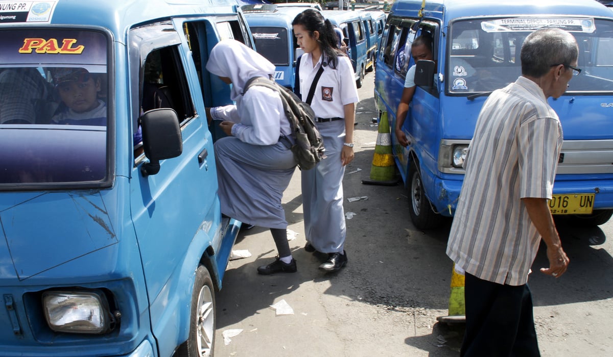 Sejumlah penumpang naik ke dalam Angkutan Kota di depan Terminal Depok, Depok, Jawa Barat.