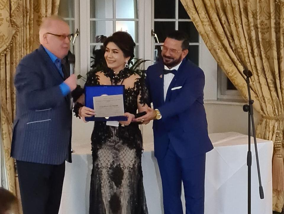 Prof. Deby Vinski sebagai presiden  WOCPM memberikan penghargaan kepada Philip Micans, MS, PharmB Ketua Kongres.