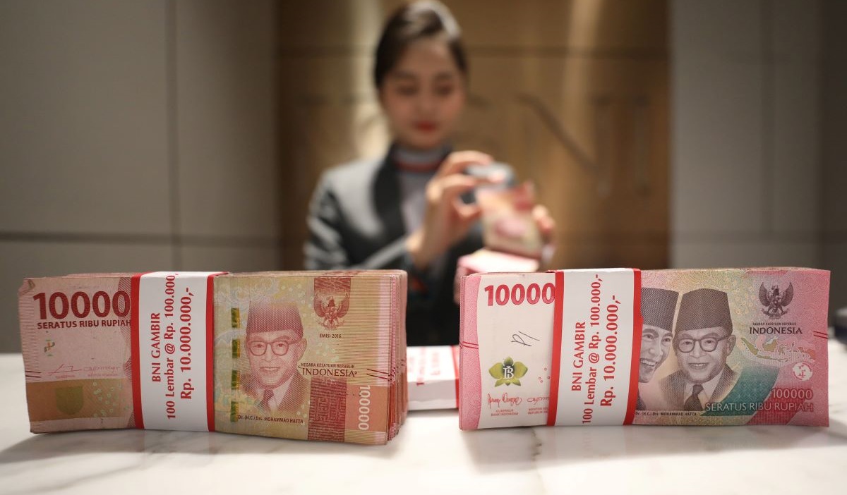 Petugas menunjukkan mata uang rupiah di salah satu kantor cabang PT Bank Negara Indonesia (BNI) Tbk. di Jakarta, Jumat (23/2/2024).