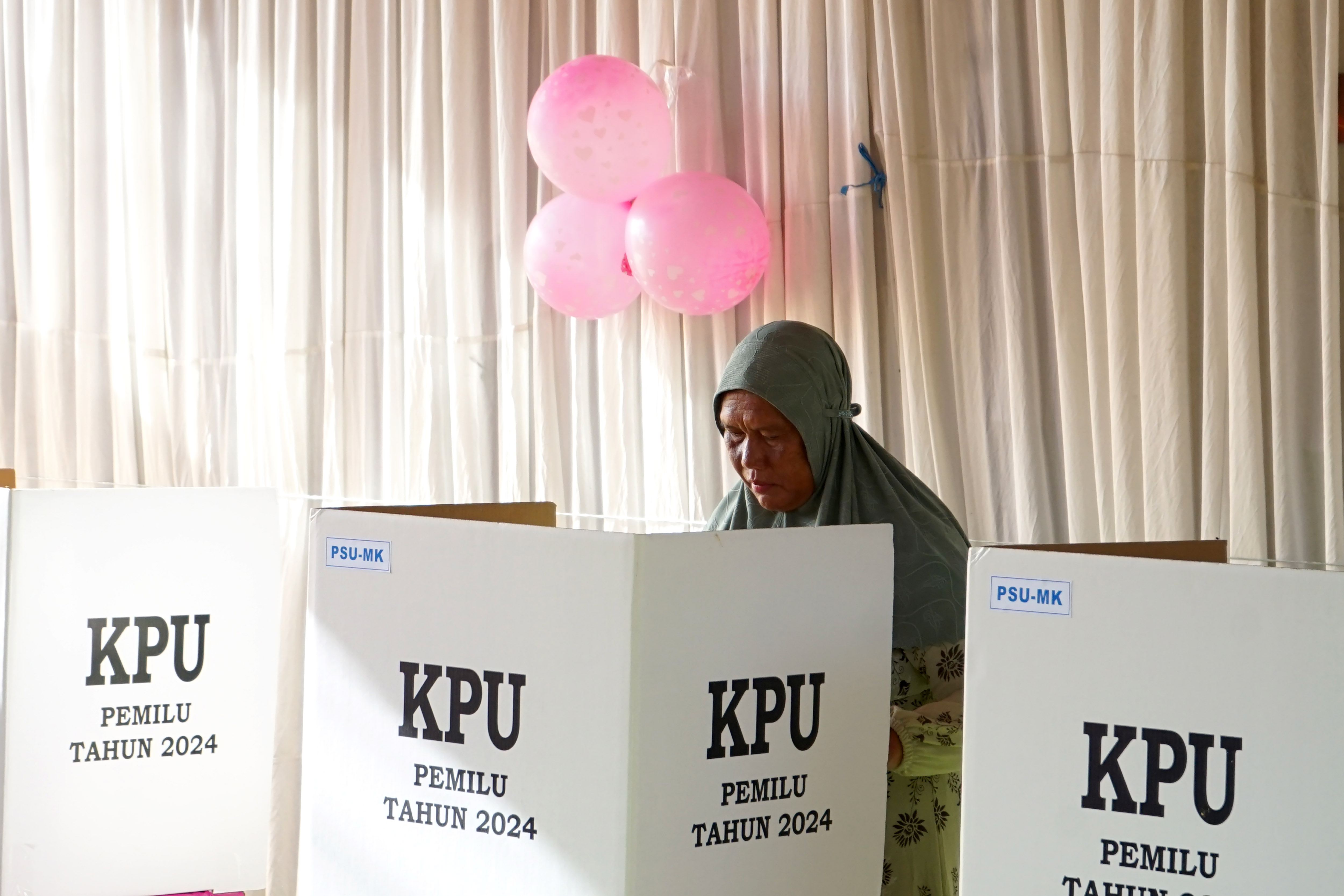 Seorang warga mencoblos di bilik suara pada Pemungutan Suara Ulang (PSU)