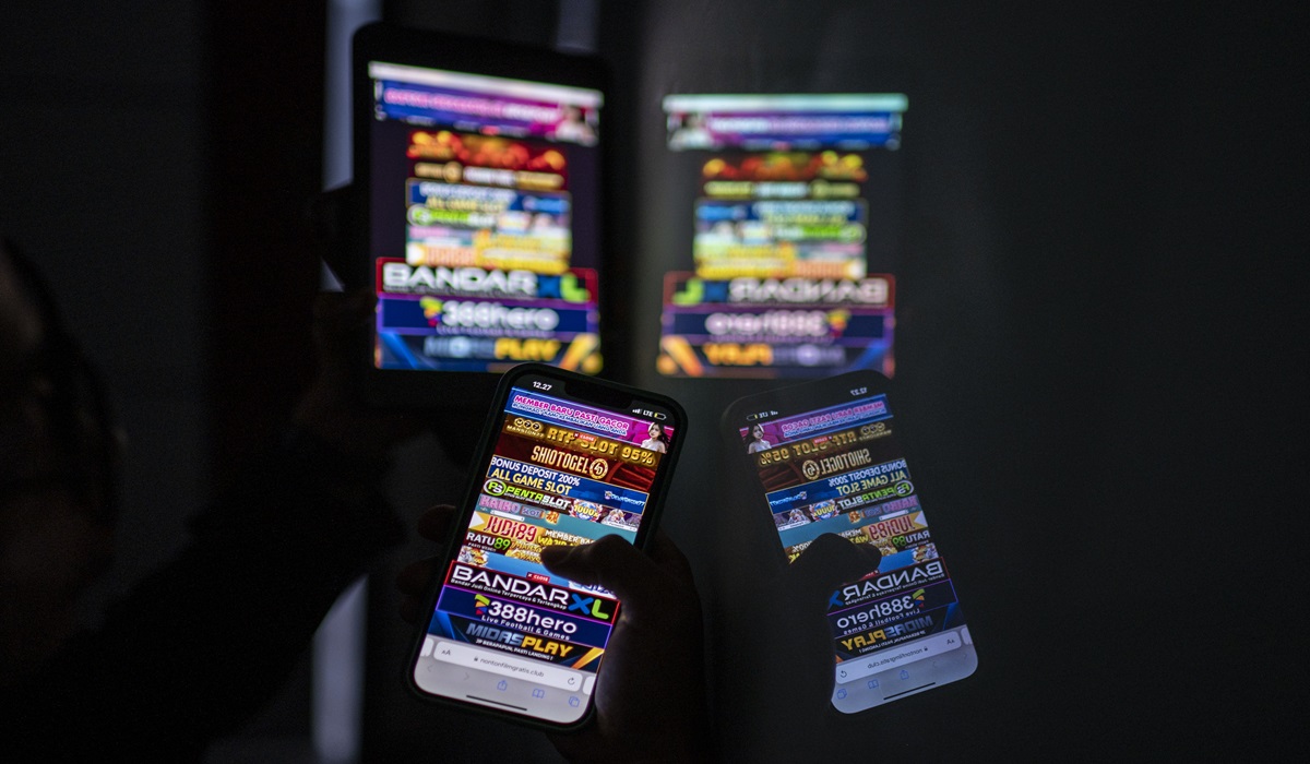 Ilustrasi--Warga melihat iklan judi online melalui gawainya di Jakarta.