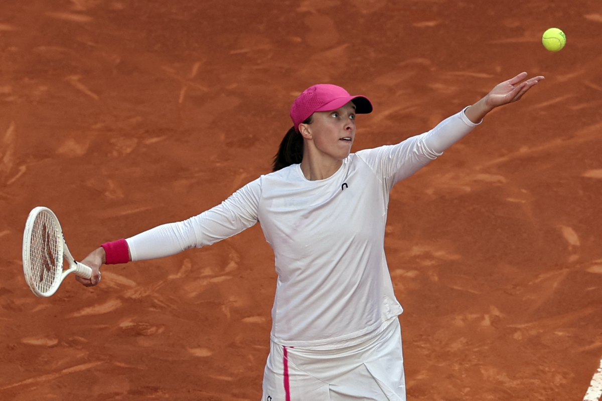 Iga Swiatek dari Polandia melakukan servis bola melawan Aryna Sabalenka dari Belarusia pada pertandingan tenis final turnamen WTA Tour Madri