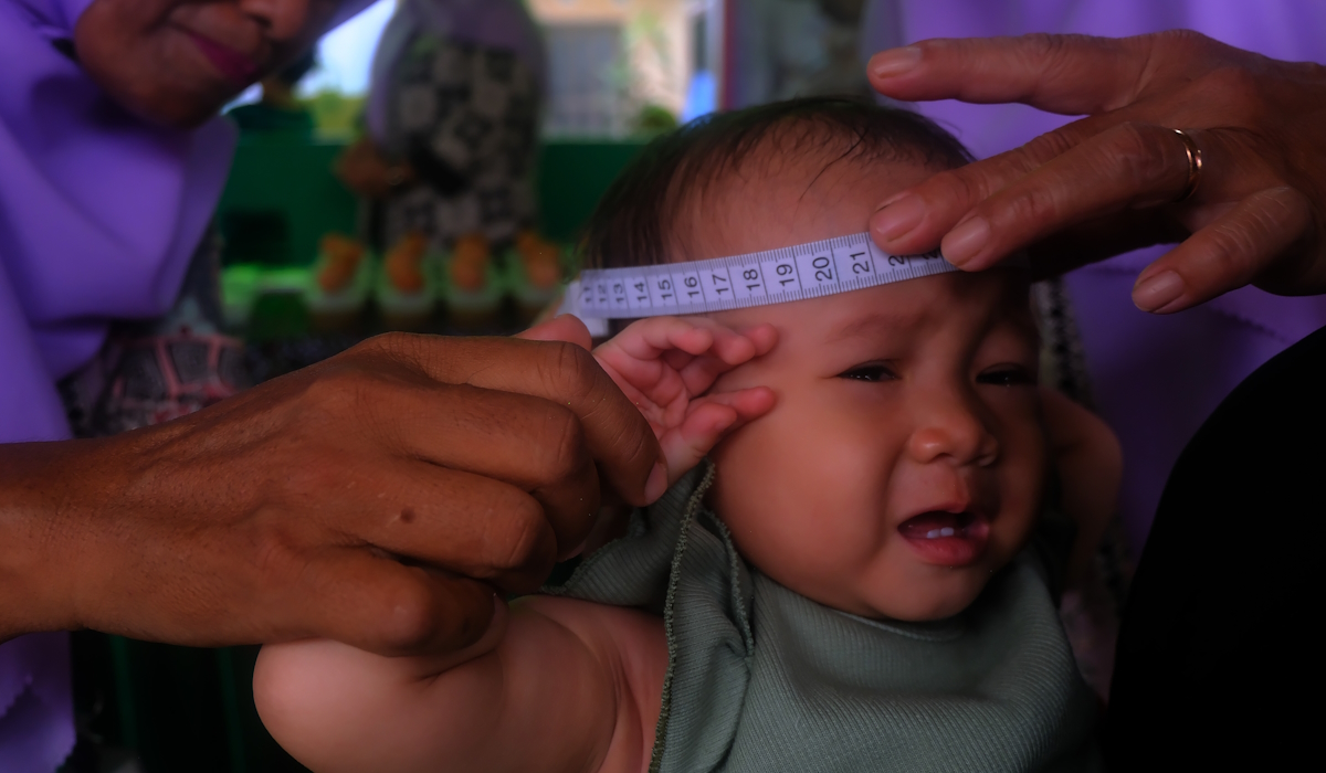 Kader posyandu mengukur lingkar kepala bayi saat pelaksanaan posyandu serentak di Kabupaten Kubu Raya