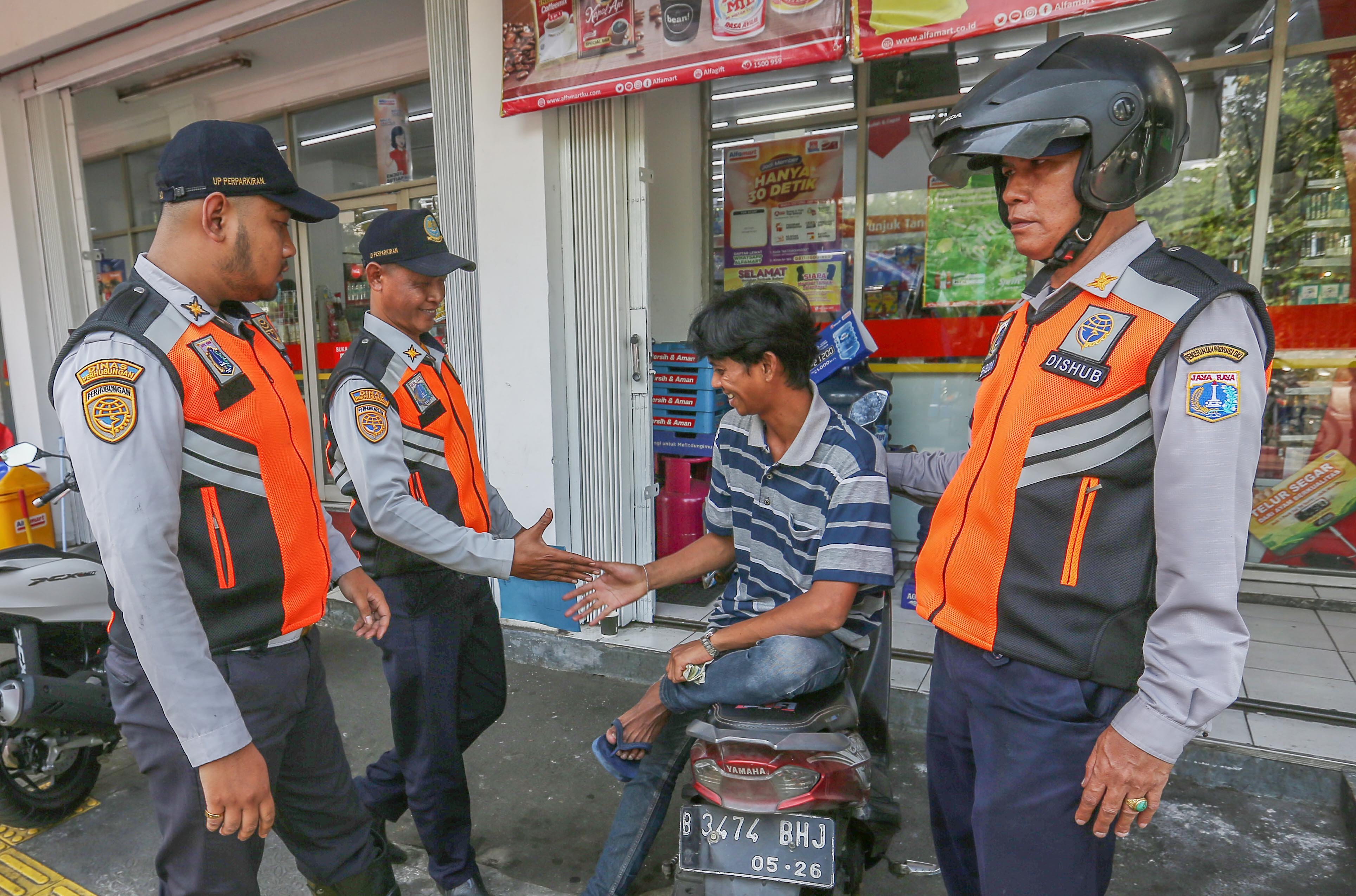 Petugas Dinas Perhubungan (Dishub) DKI melakukan sosialisasi larangan parkir liar di minimarket di kawasan Senen, Jakarta Pusat.