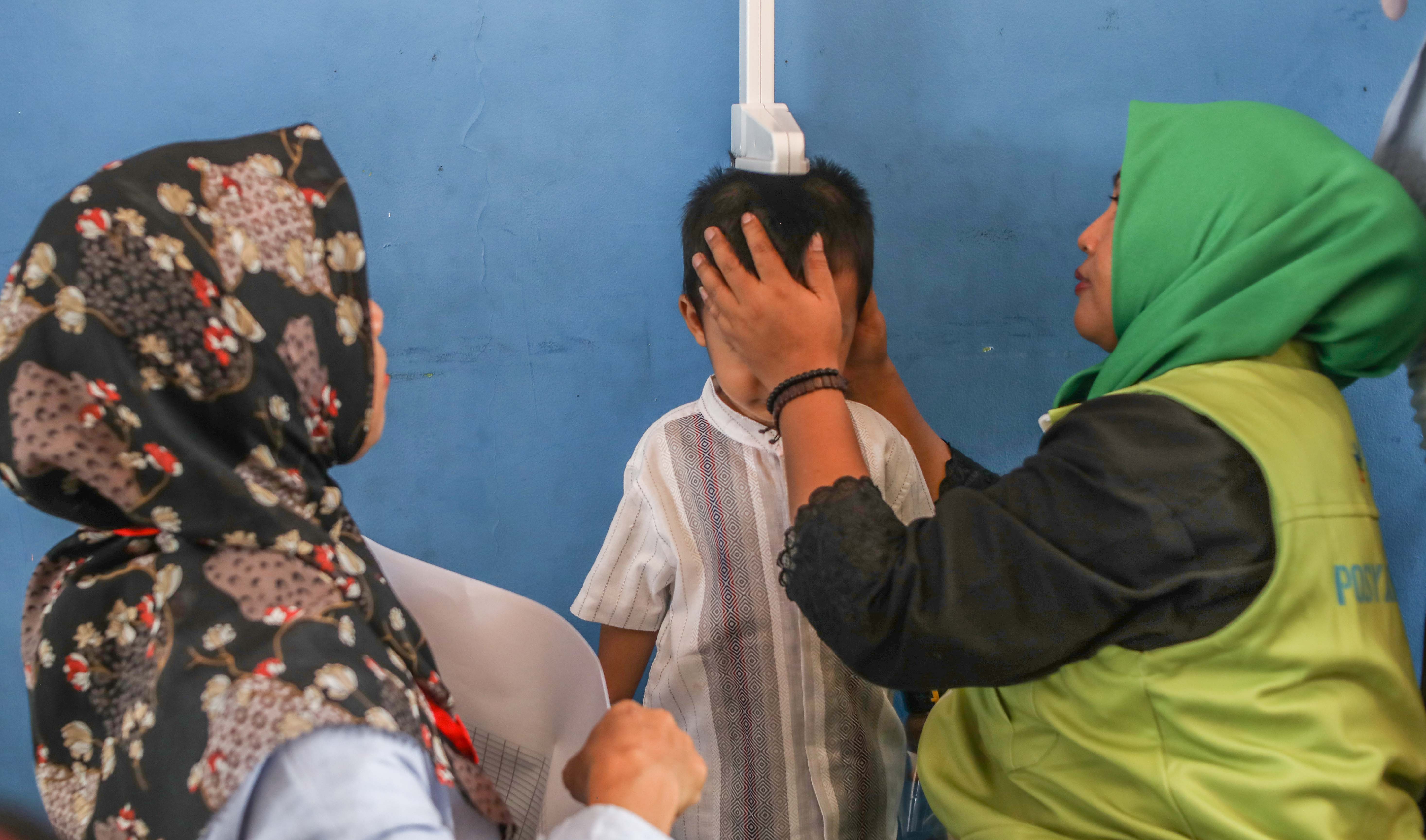 Para orang tua menimbangkan balitanya di Pos Pelayanan Terpadu