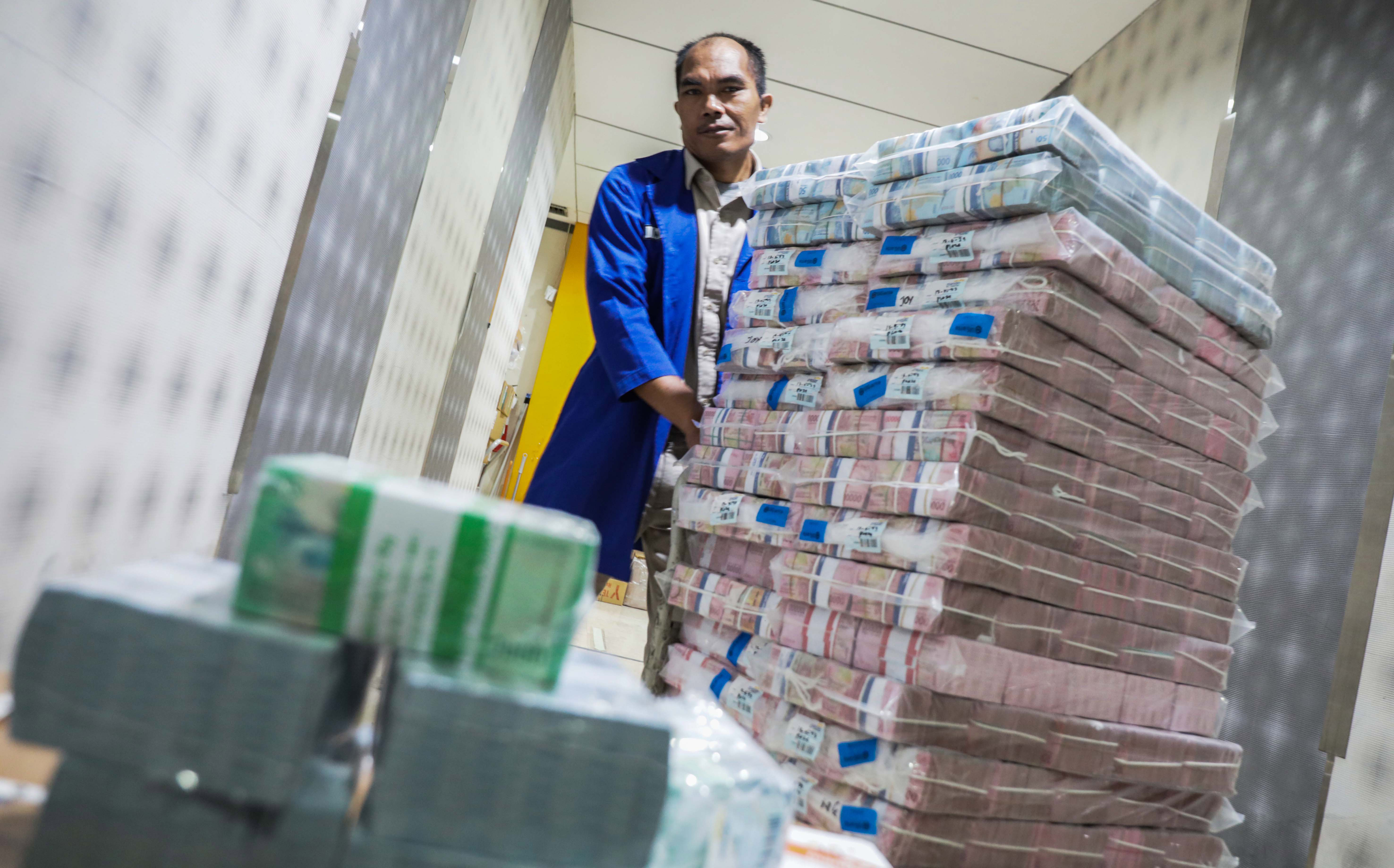 Petugas mengecek uang tunai