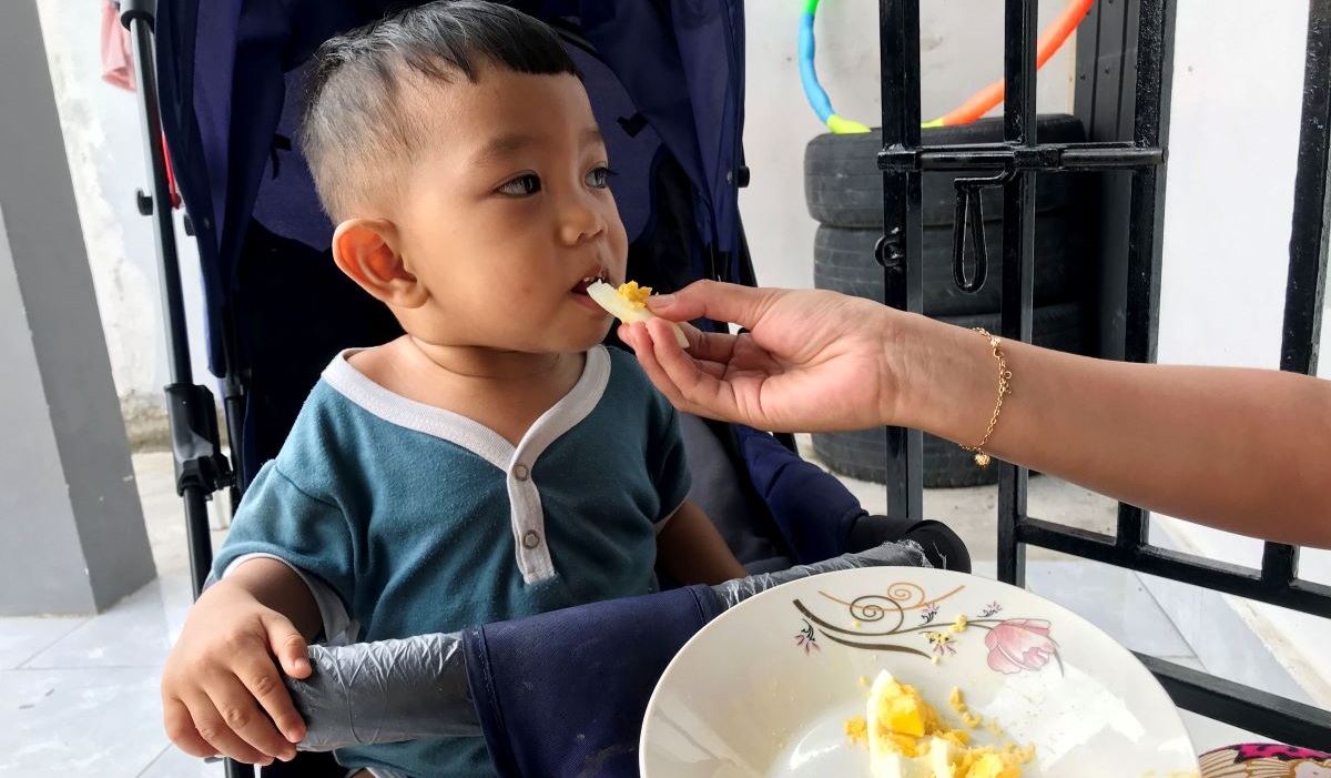 Seorang balita mengkonsumsi telur ayam yang disuap oleh ibunya di wilayah Tatanga, Palu, Sulawesi Tengah, Selasa 7 Mei 2024.