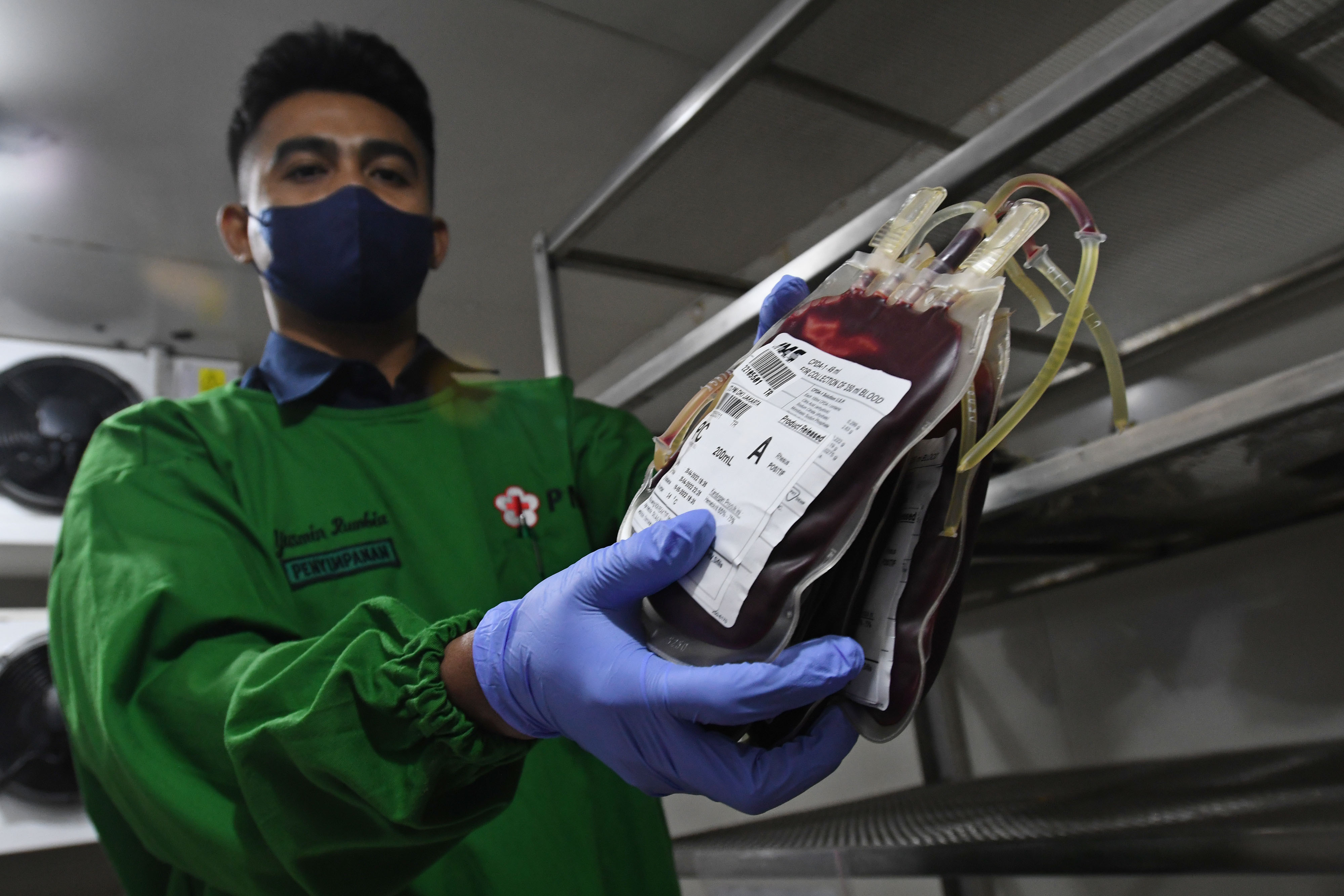 Petugas menunjukkan kantong berisi darah pendonor di ruang penyimpanan Palang Merah Indonesia (PMI) DKI Jakarta, Jakarta, Selasa (26/4/2022)