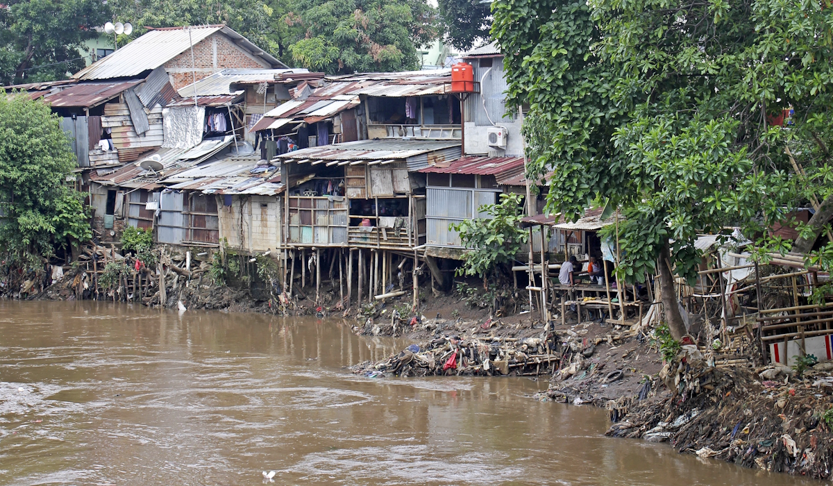 Ilustrasi: sejumlah warga duduk di rumahnya di bantaran kali Ciliwung kawasan Manggarai