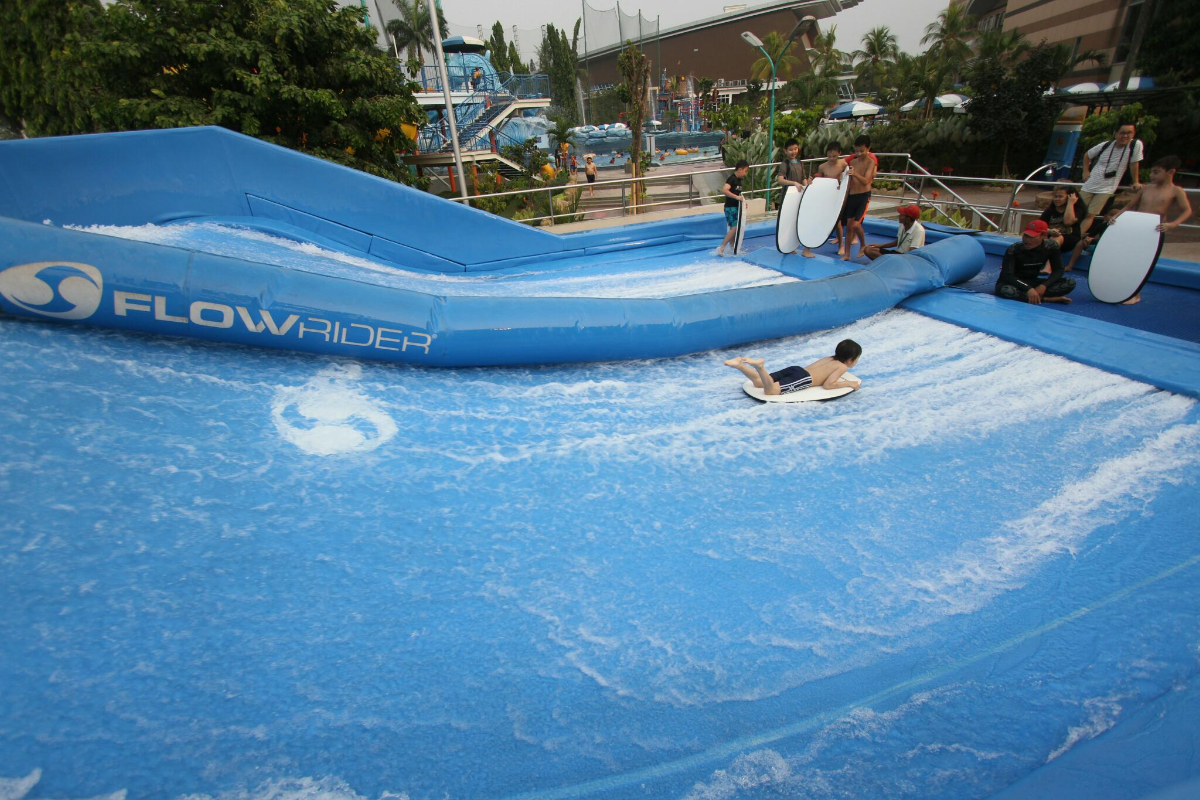  Sejumlah pengunjung berselancar di wahana Flow Rider, The Wave Pondok Indah Water Park, Jakarta