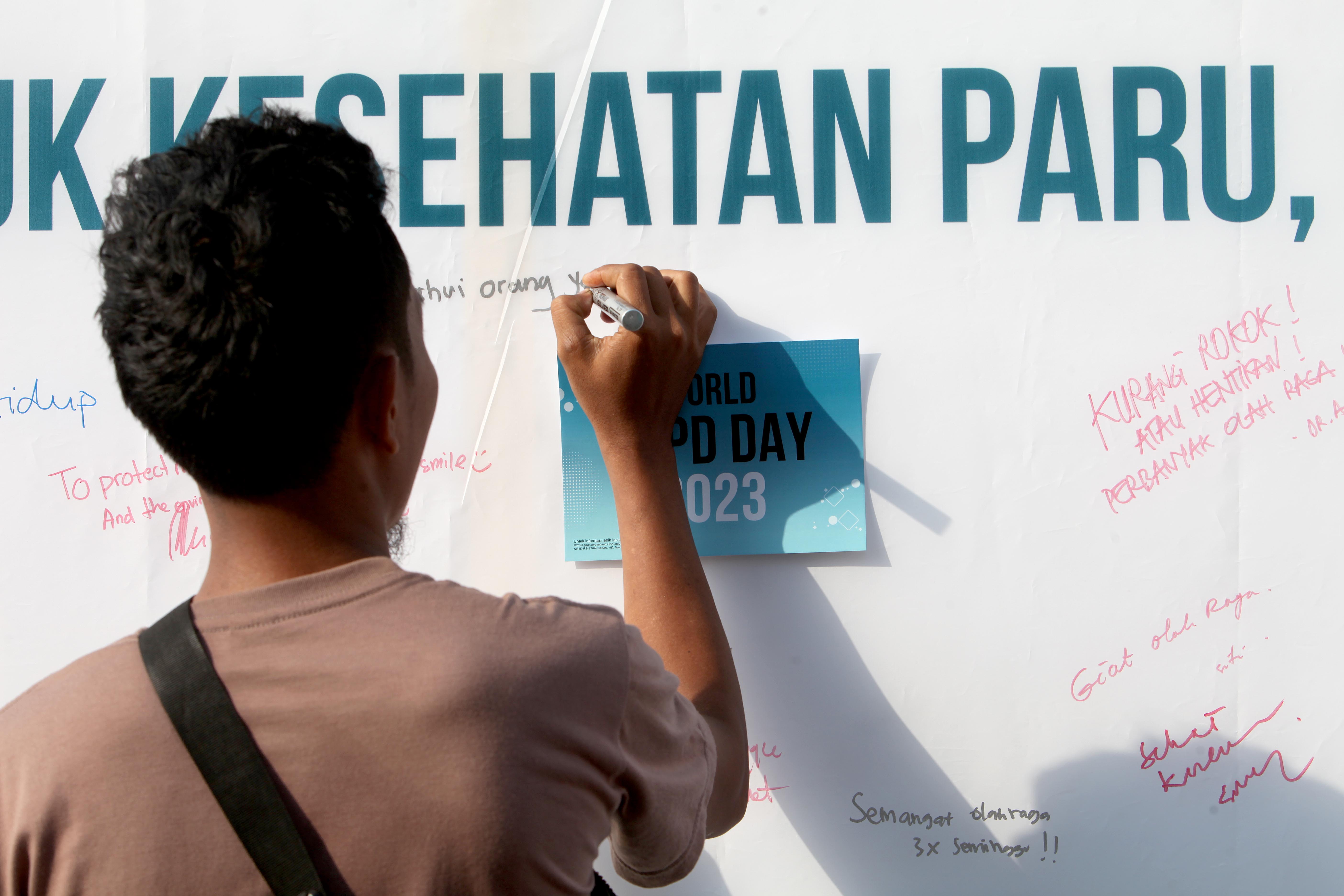 Masyarakat menuliskan pesan-pesan kesehatan di papan yang tersedia dalam peluncuran kampanye #PeduliParuOK di Jakarta,  Minggu (19/11/2023) 