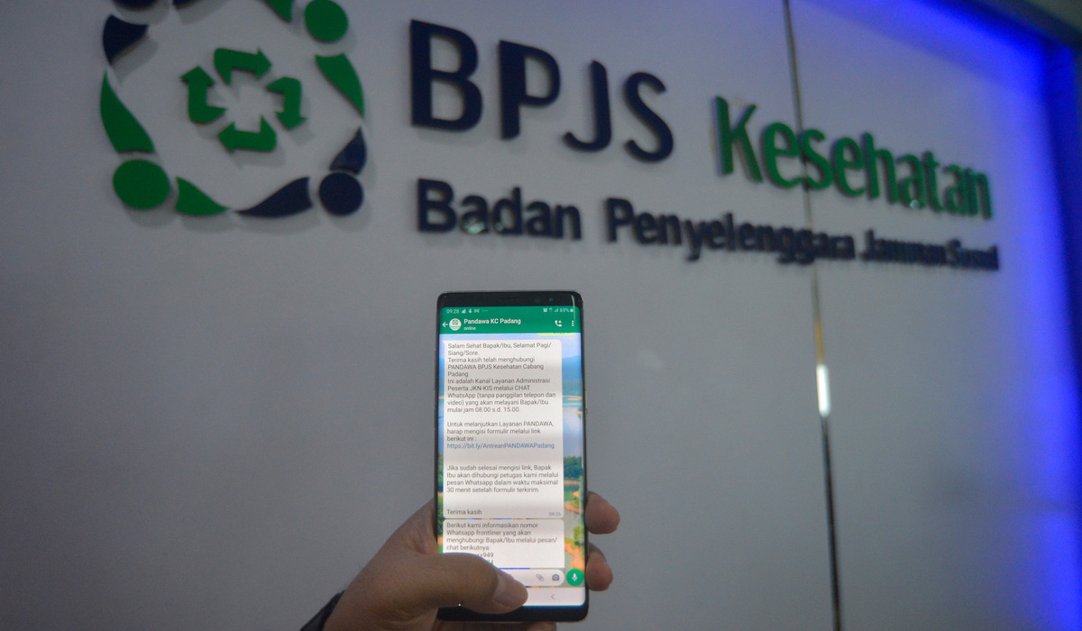 Petugas menunjukan cara pelayanan administrasi menggunakan Whatsapp di kantor BPJS Kesehatan.