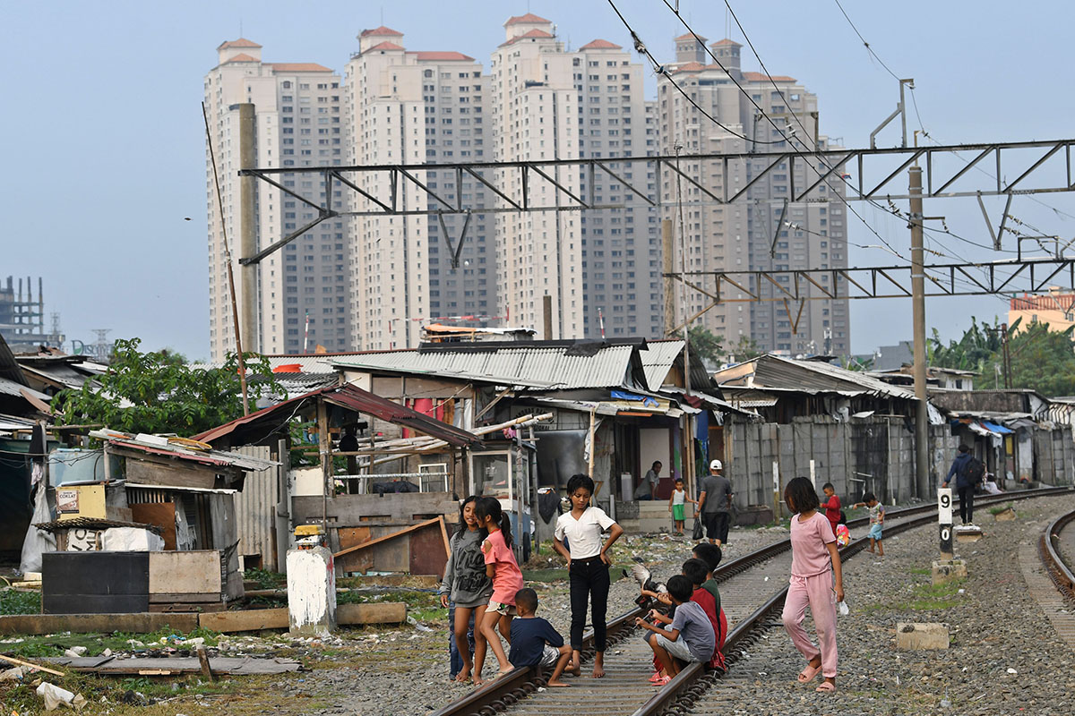 Sejumlah bocah bermain di perkampungan padat penduduk tepi rel kereta api di Kampung Bandan, Jakarta, Jumat (14/10/2022). 