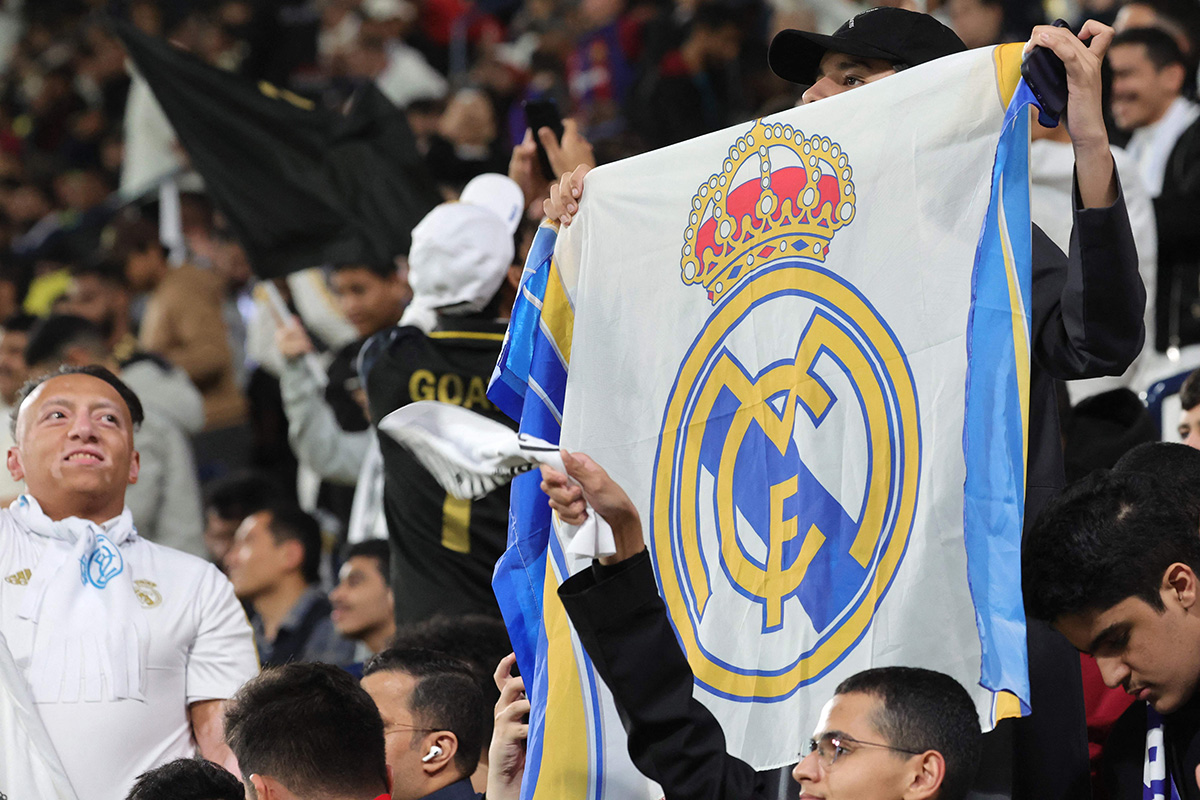 Suporter Real Madrid mengibarkan bendera klub kesayangan mereka.