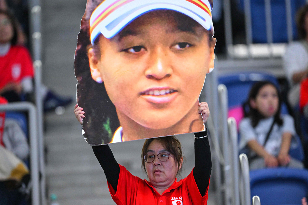 Penggemar mengangkat foto Naomi Osaka.