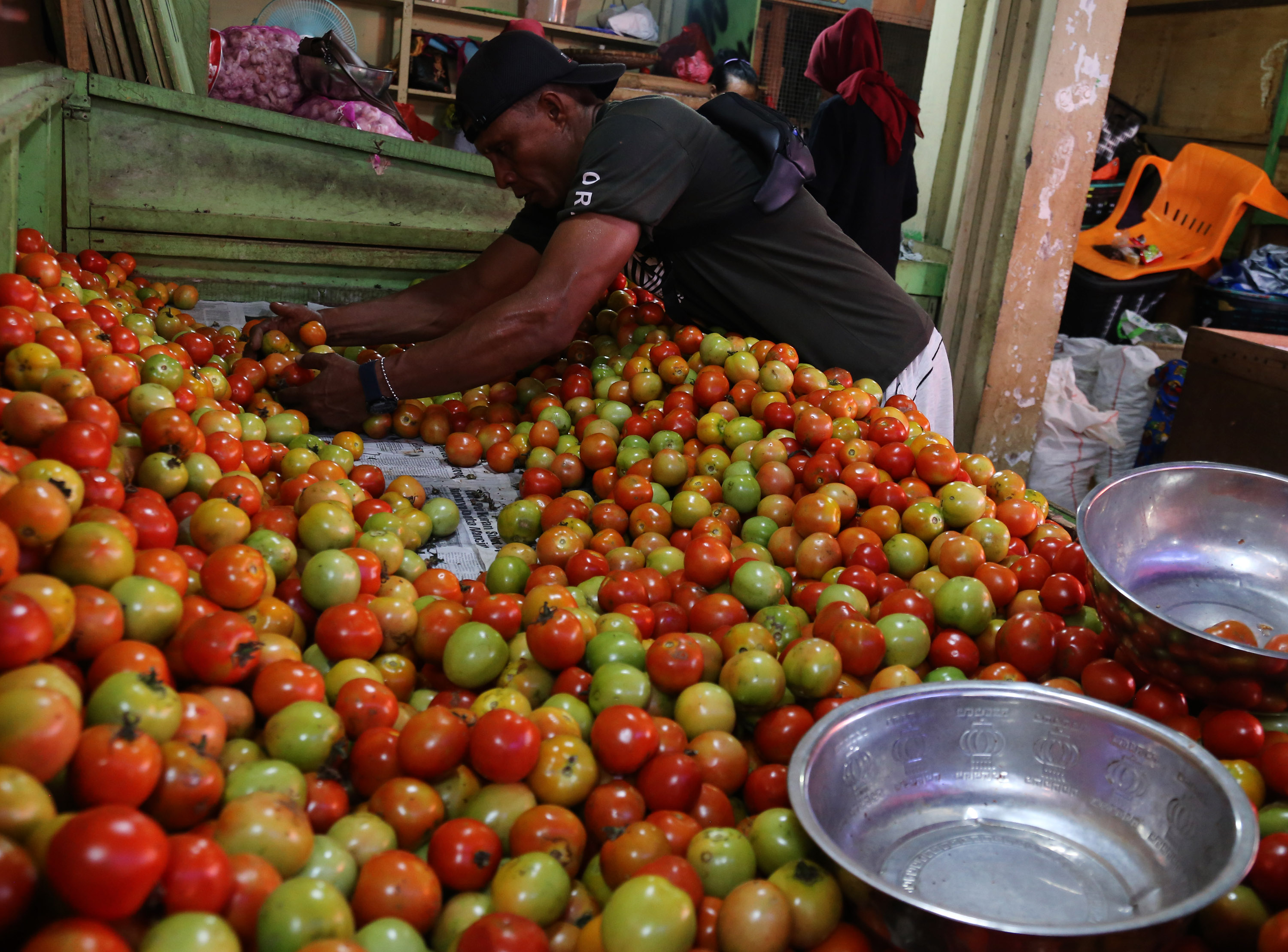 Pedagang menata buah tomat jualanya di Pasar tradisioanl