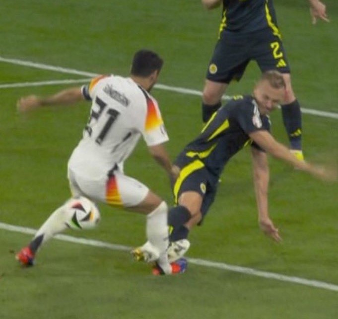 Ryan Porteous melakukan tekel dengan dua kaki di tepi kotak penalti terhadap kapten Jerman Ilkay Gundogan. 