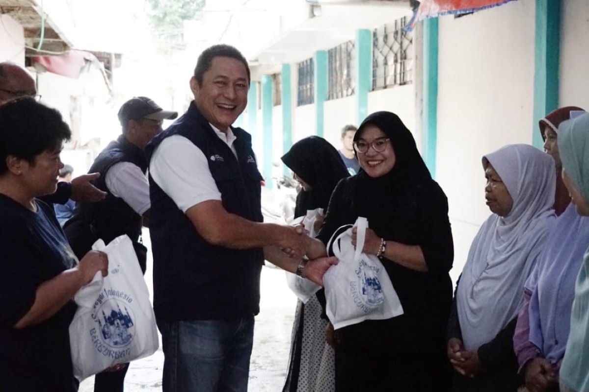 Direktur Utama PT Surveyor Indonesia, Sandry Pasambuna, membagikan daging kurban kepada masyarakat.