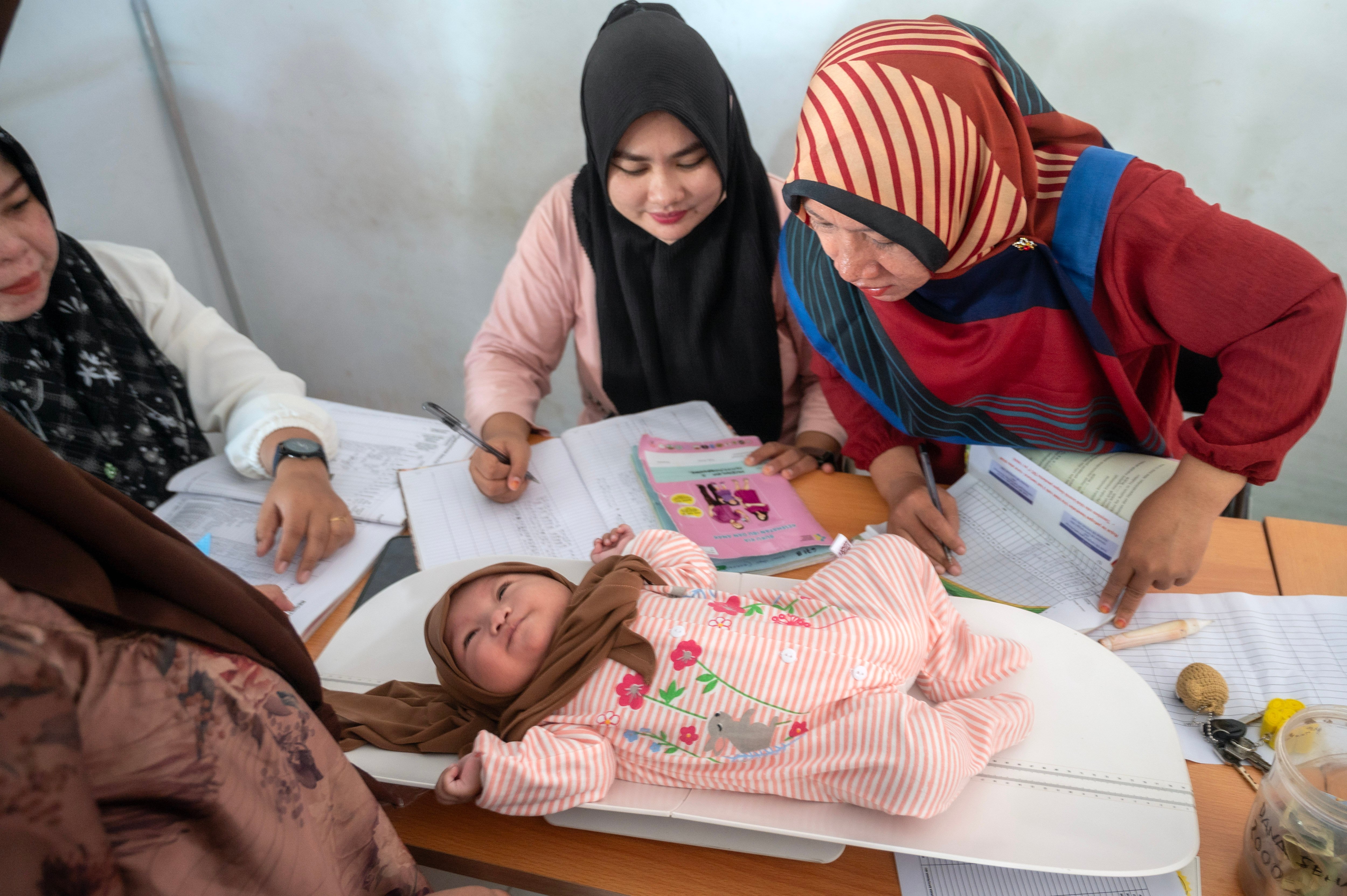 Ilustrasi--Petugas kesehatan menimbamng seorang anak balita saat pelayanan kesehatan di sebuah Posyandu.