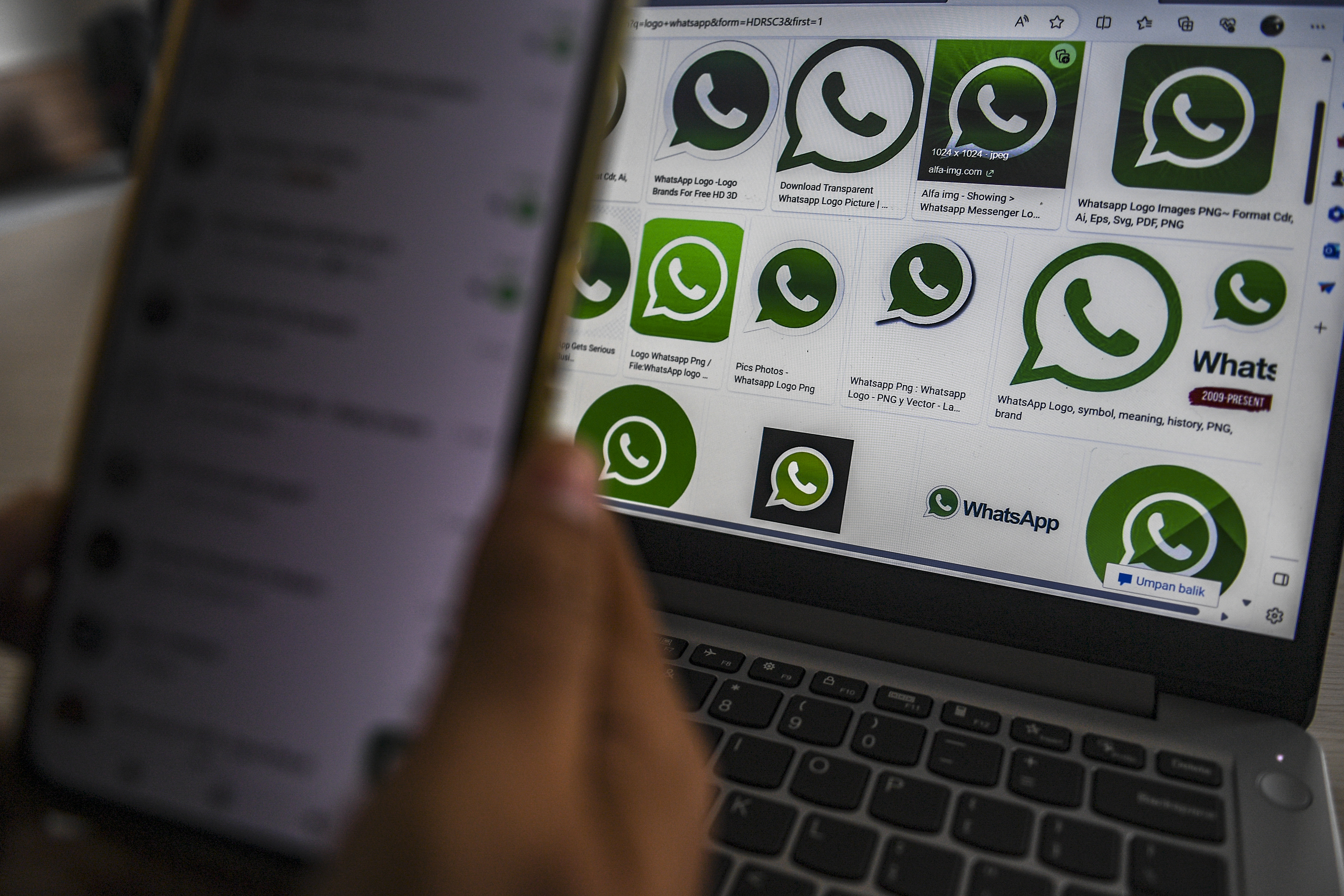 Warga menampilkan logo WhatsApp