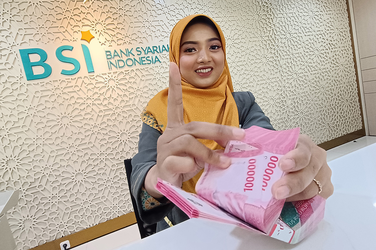 Teller Bank Syariah Indonesia tengah menghitung uang.