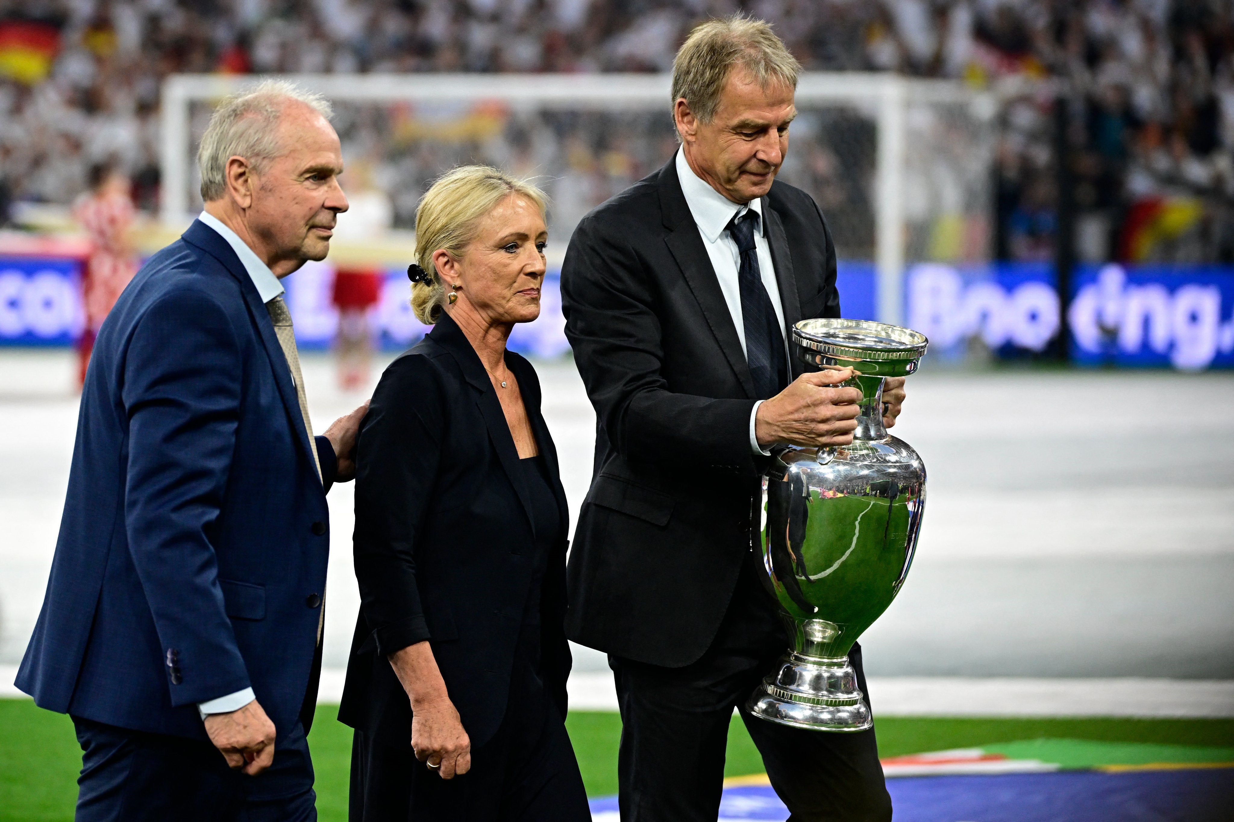 Istri Franz Beckenbauer, Heidi bersama legenda Jerman lainnya, Bernard Dietz dan Jurgen Klinsmann membawa Piala Henri Delaunay.