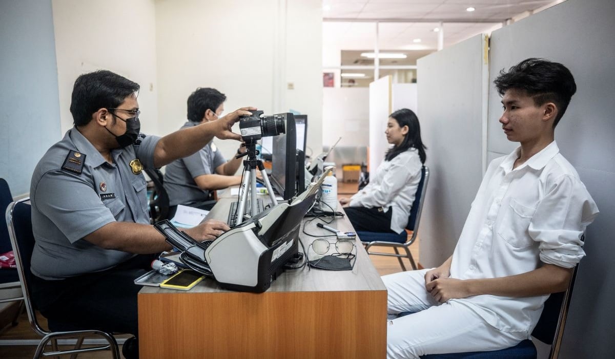 Petugas Imigrasi memotret pemohon paspor di Kantor Imigrasi Kelas 1 Khusus Non TPI Jakarta Barat, Jakarta, Senin (24/6/2024).