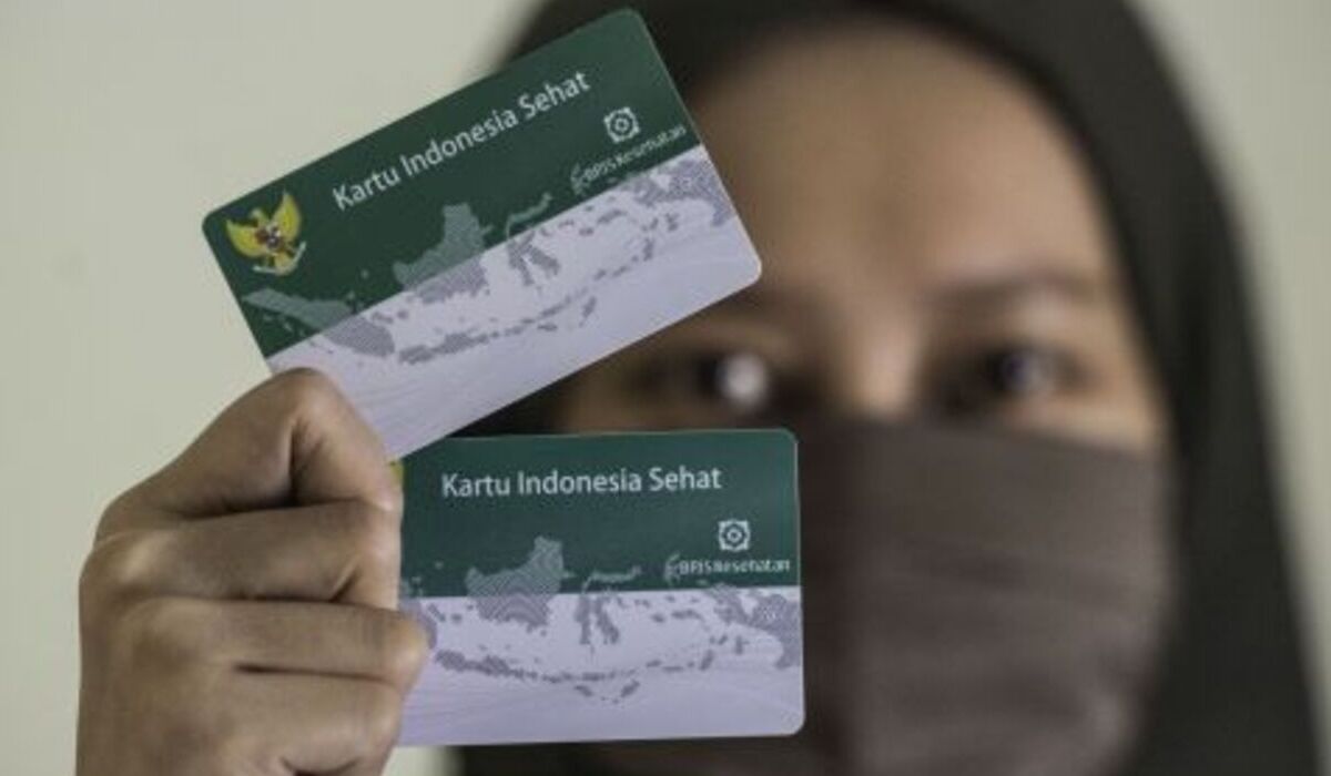 Warga menunjukkan Kartu Indonesia Sehat BPJS Kesehatan.