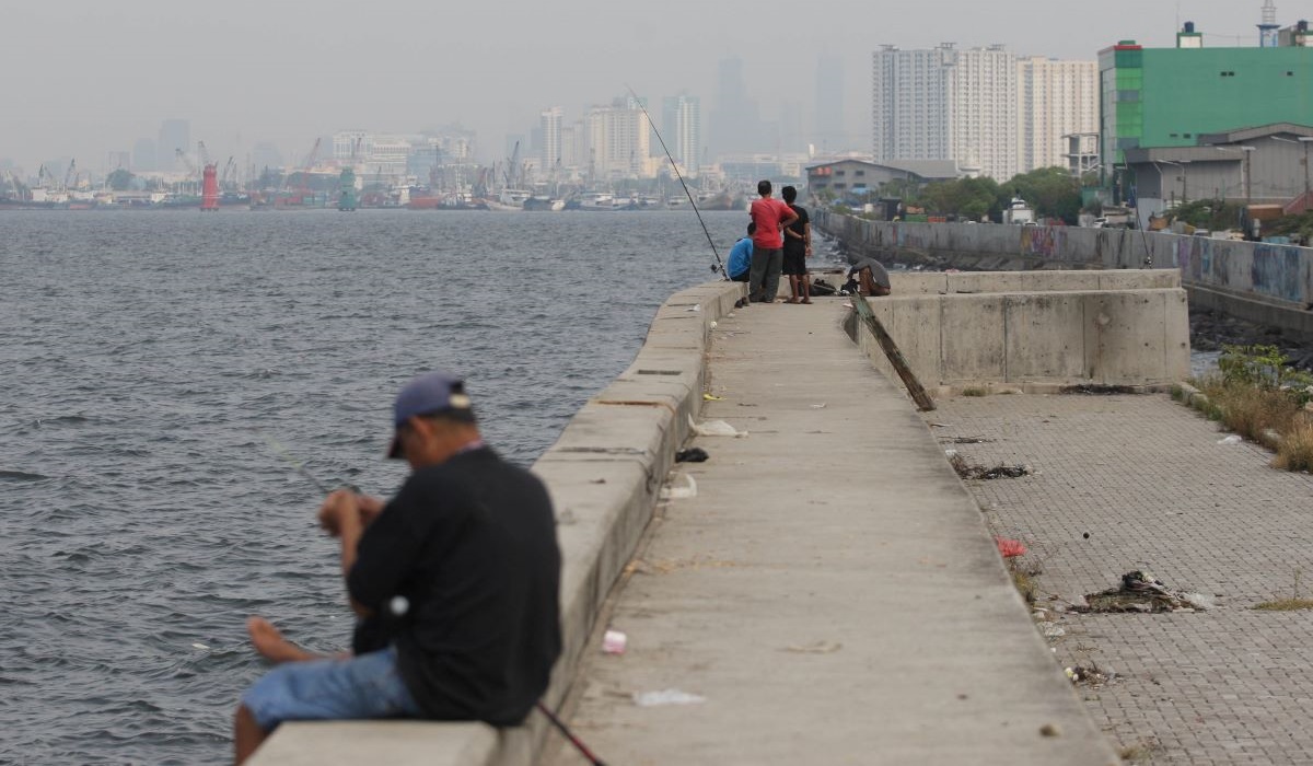 Warga memancing di tanggul laut Muara Baru, Jakarta Utara, Rabu (24/05/2023).