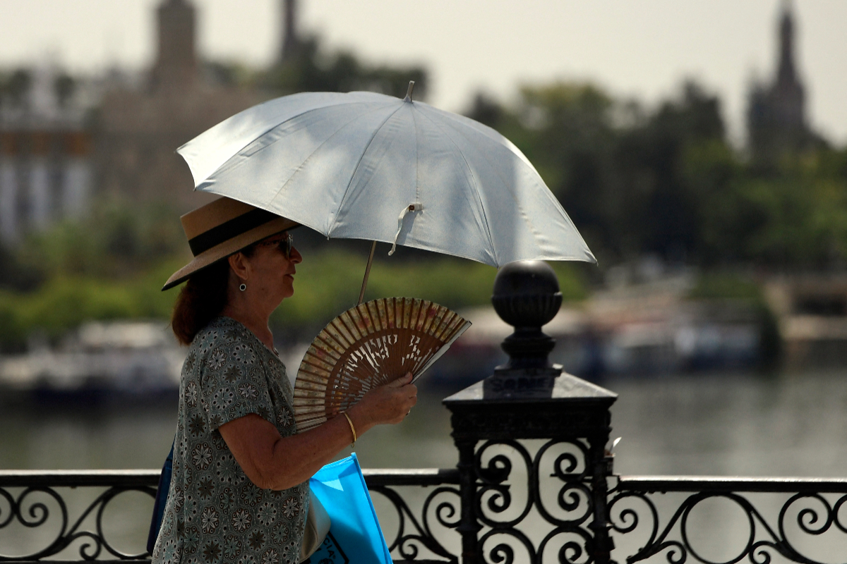 Ilustrasi, Seorang wanita menggunakan payung dan kipas angin untuk melindungi dirinya dari sinar matahari dan suhu tinggi