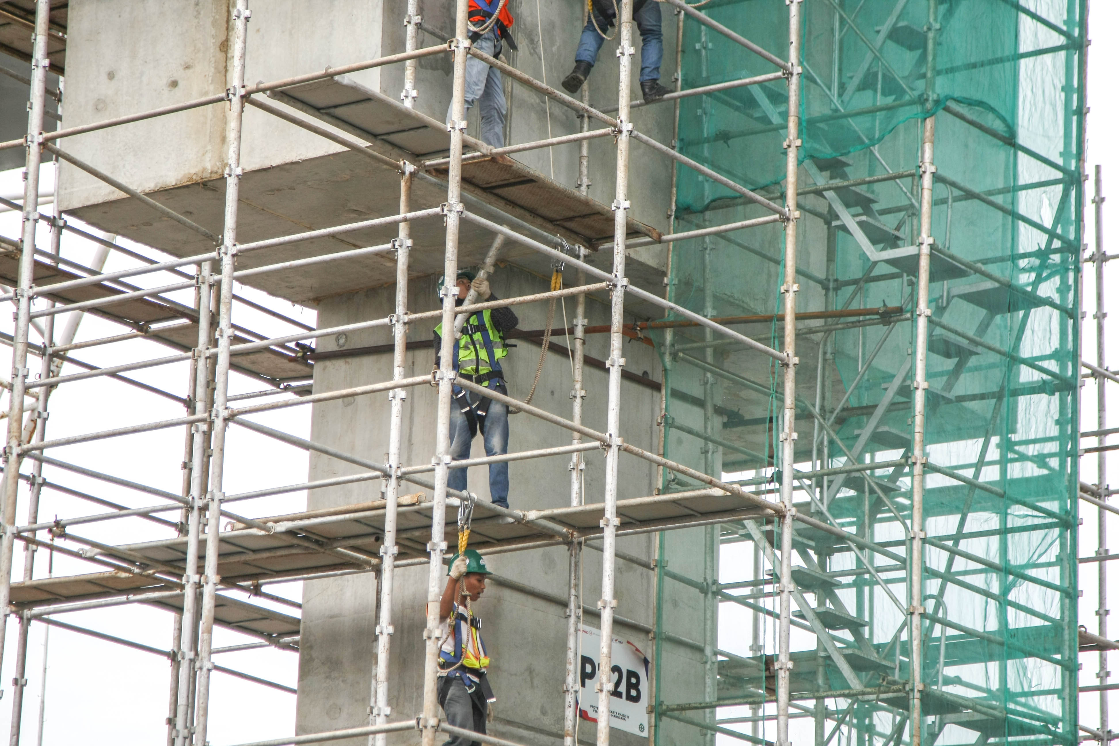 Pekerja menyelesaikan pembuatan konstruksi.