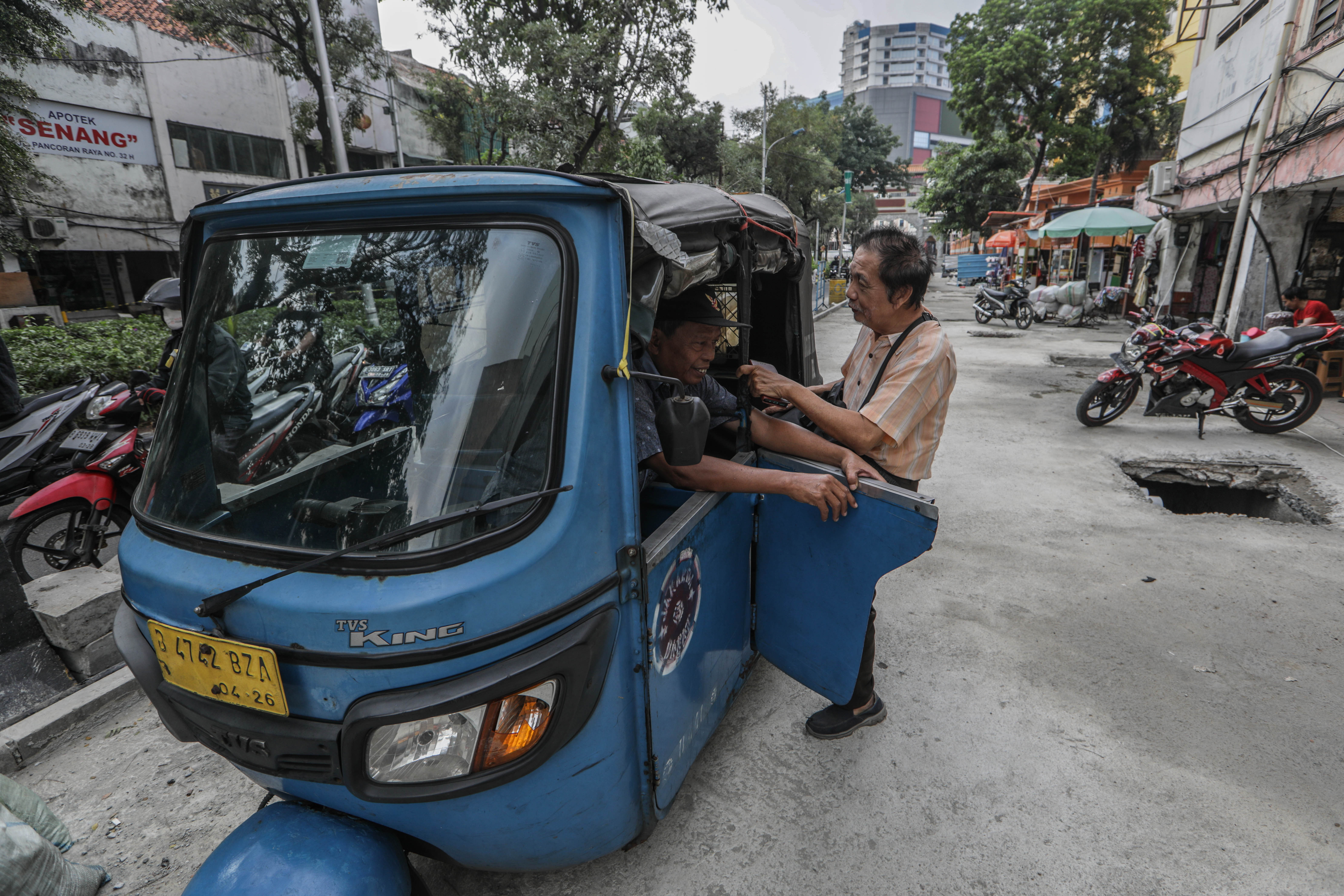 Sopir Bajaj menunggu penumpang di lokasi proyek revitalisasi trotoar di kawasan Glodok Pancoran