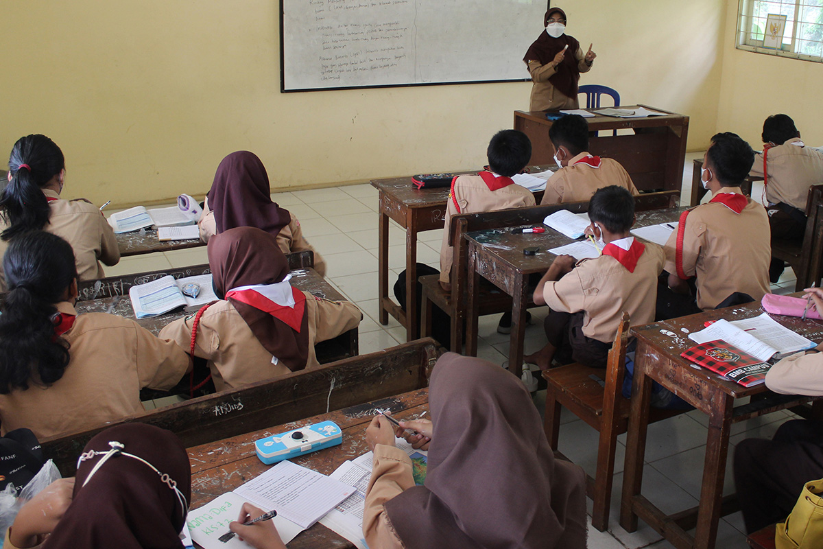 Ilustrasi guru honorer tengah mengajar di kelas.