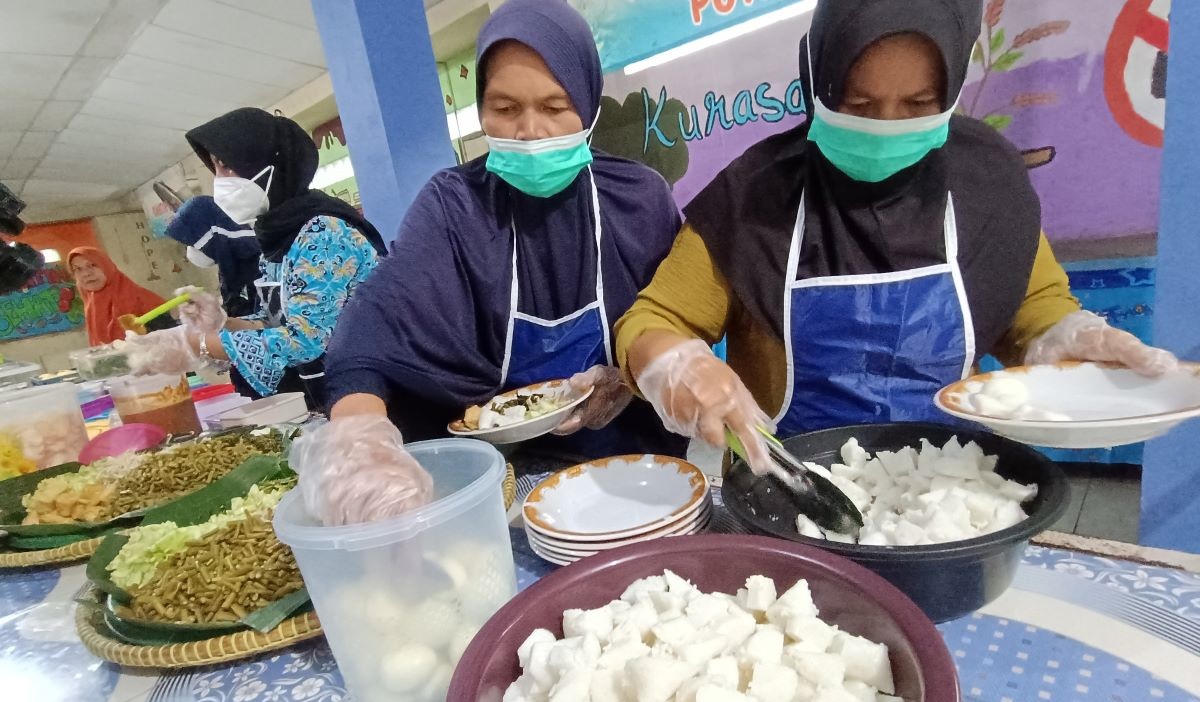 Petugas dinas kesehatan menyiapkan makan siang gratis dalam simulasi yang digelar di SMP Negeri 2 Curug, Tangerang, Banten.