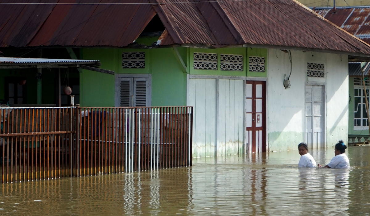 Ilustrasi: warga melintasi banjir di Telaga Jaya, Kabupaten Gorontalo
